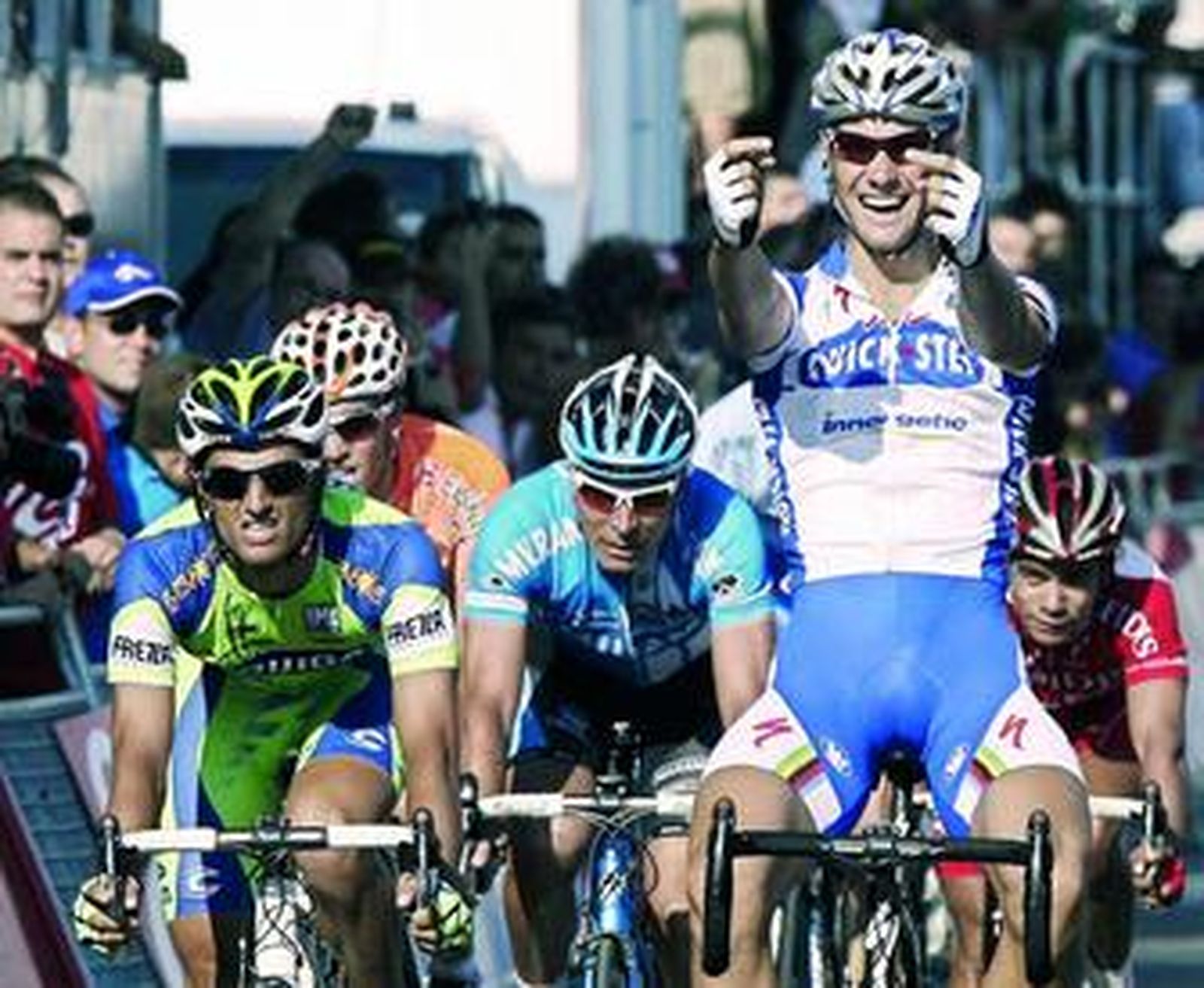 Boonen levanta las manos en la línea de meta tras superar a Bennati y Zabel.
