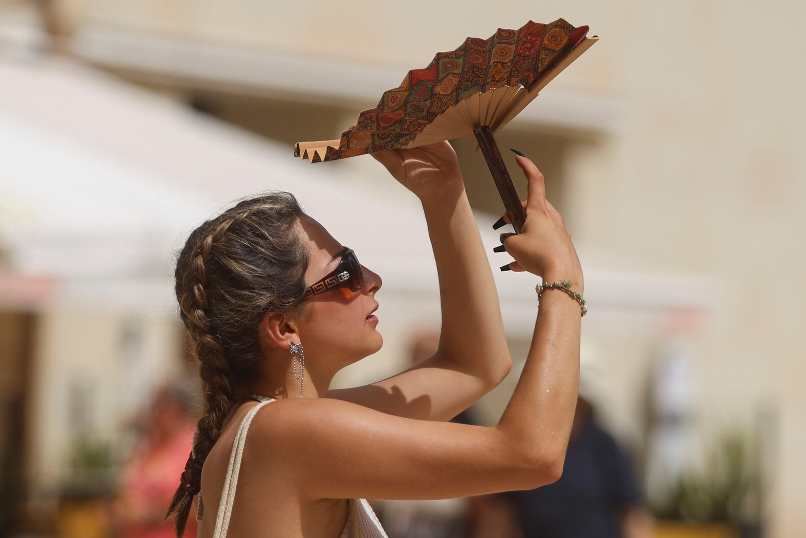 Imagen de archivo de una mujer protegiéndose del sol.