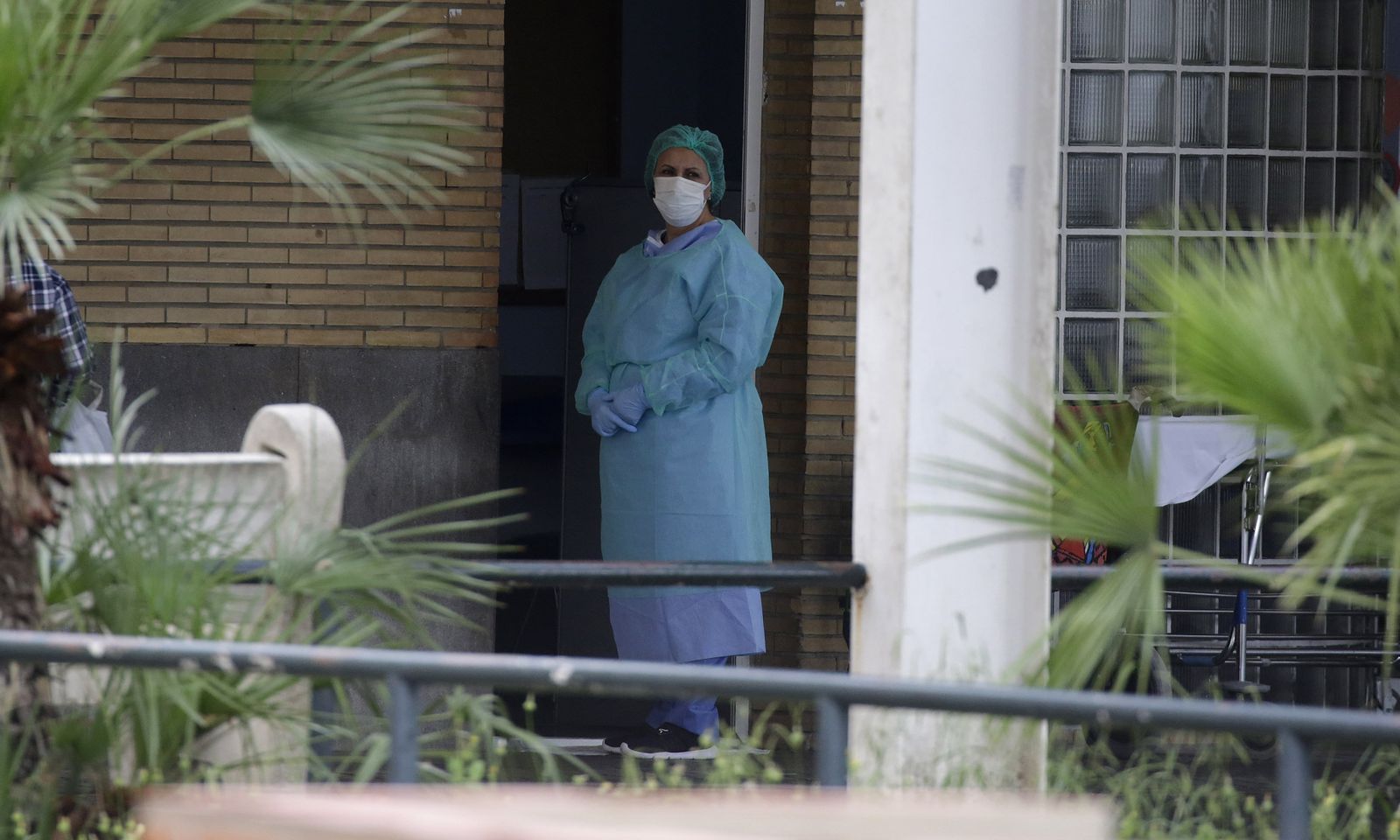 Una sanitaria, con la mirada perdida al frente, en una de las entradas de personal del Virgen del Rocío.