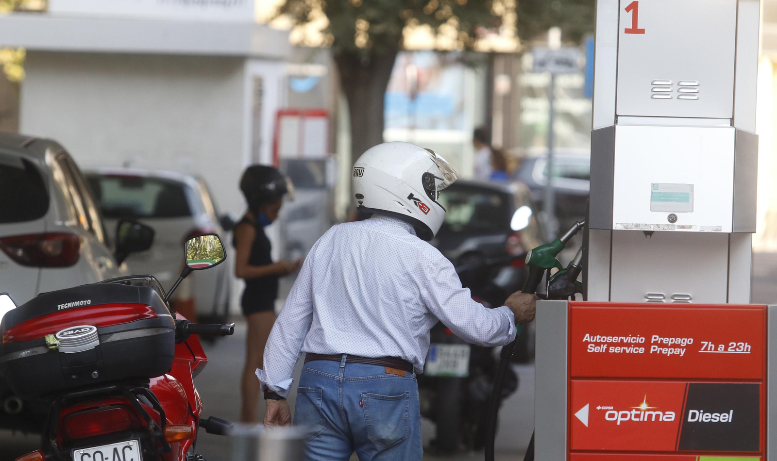 Hombre reposta su vehículo en una gasolinera.