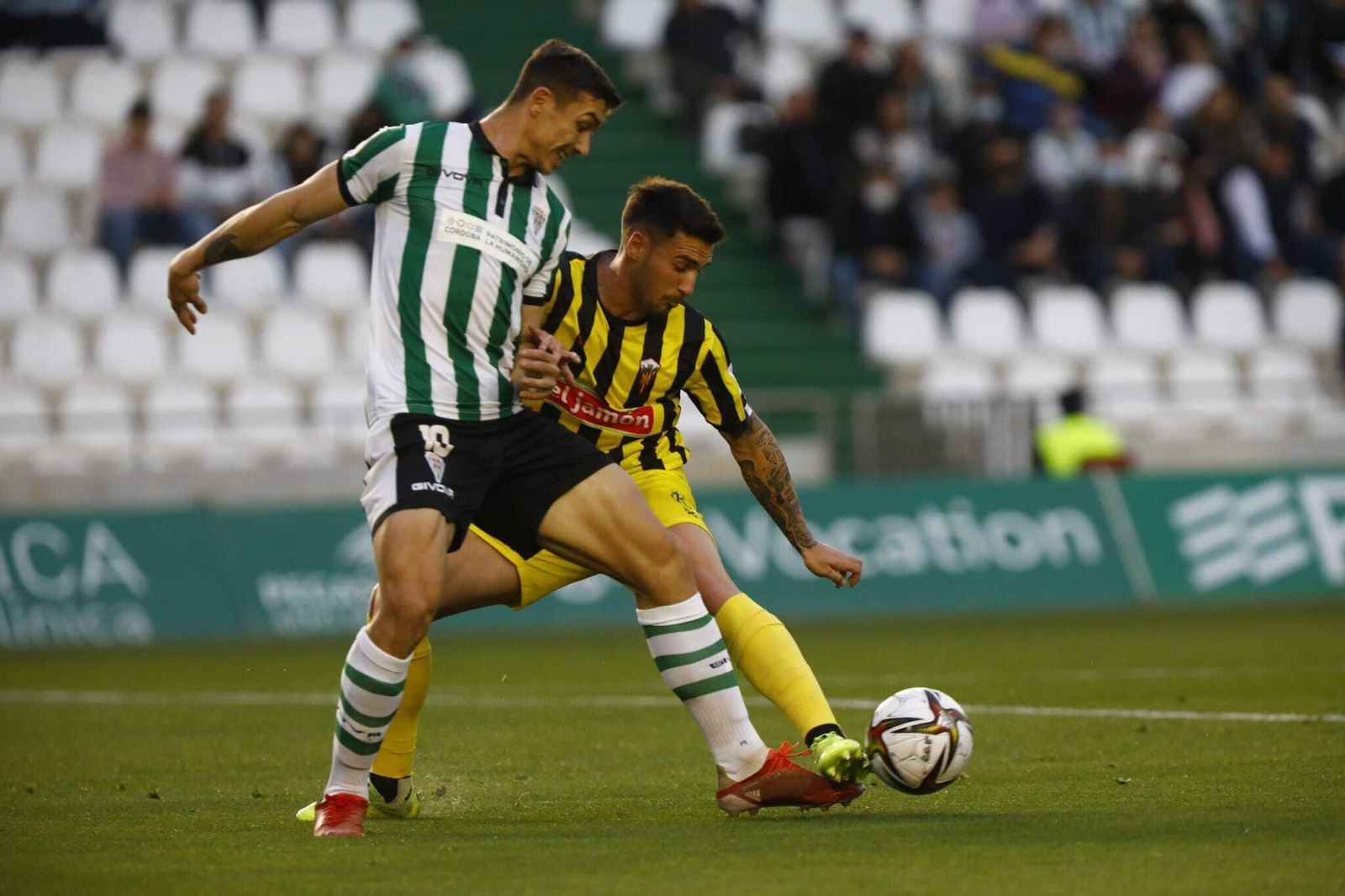 Adrián Fuentes lucha un balón con Iván Robles, del San Roque de Lepe.