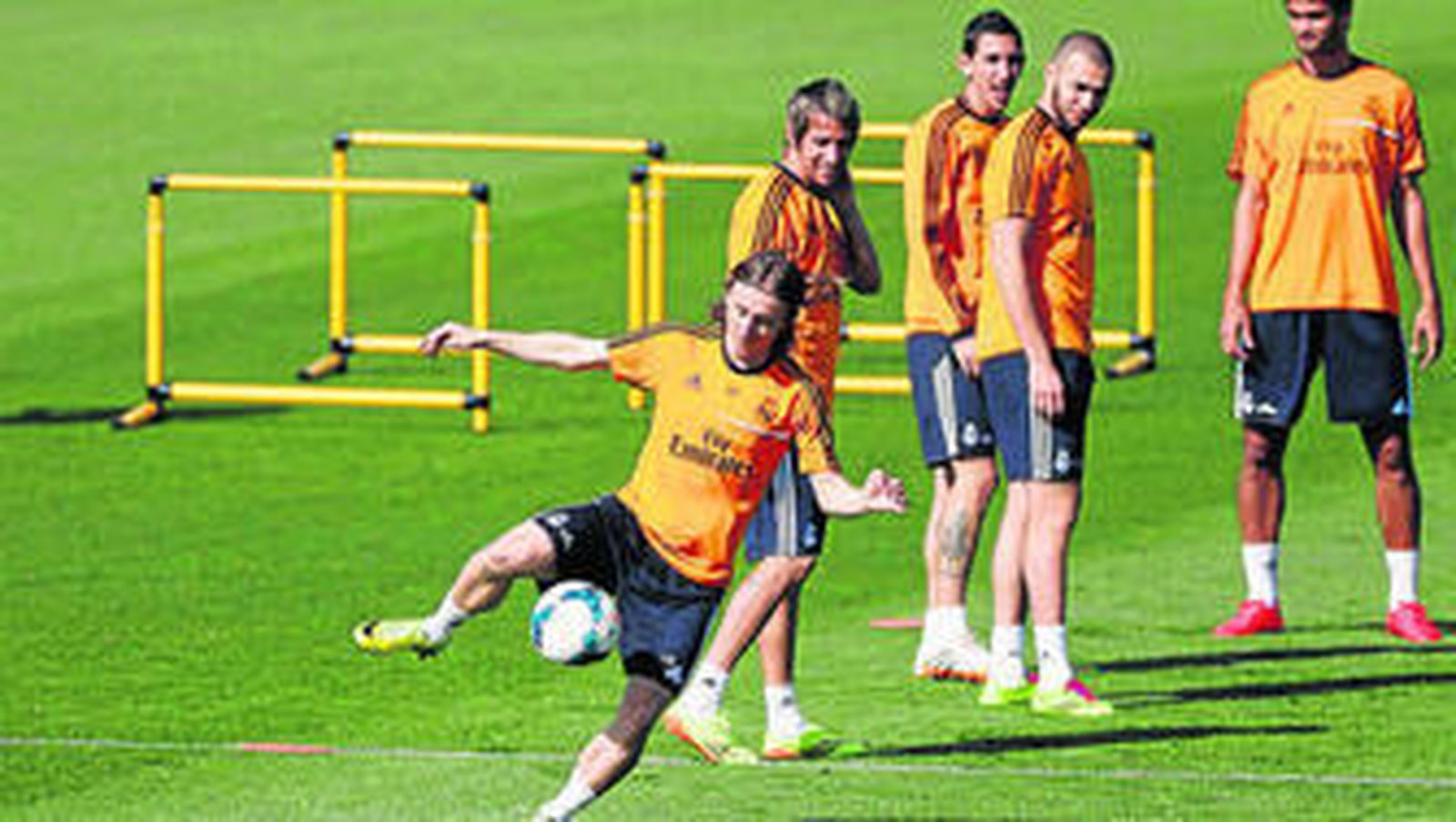 Varios futbolistas del Madrid observan un ejercicio de Modric en el entrenamiento.