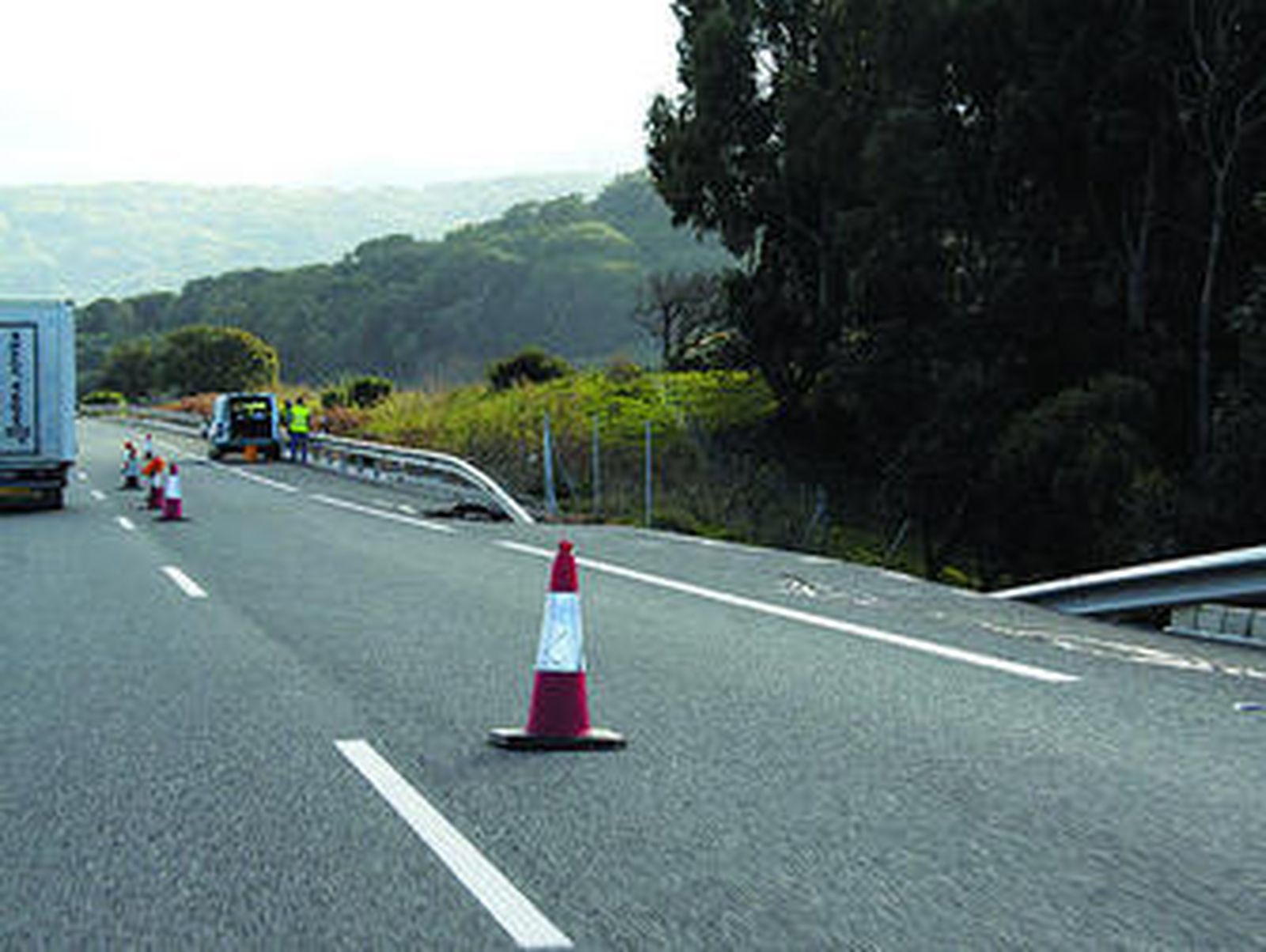 Vista del tramo afectado por el deslizamiento y los empleados encargados de su reparación, ayer.
