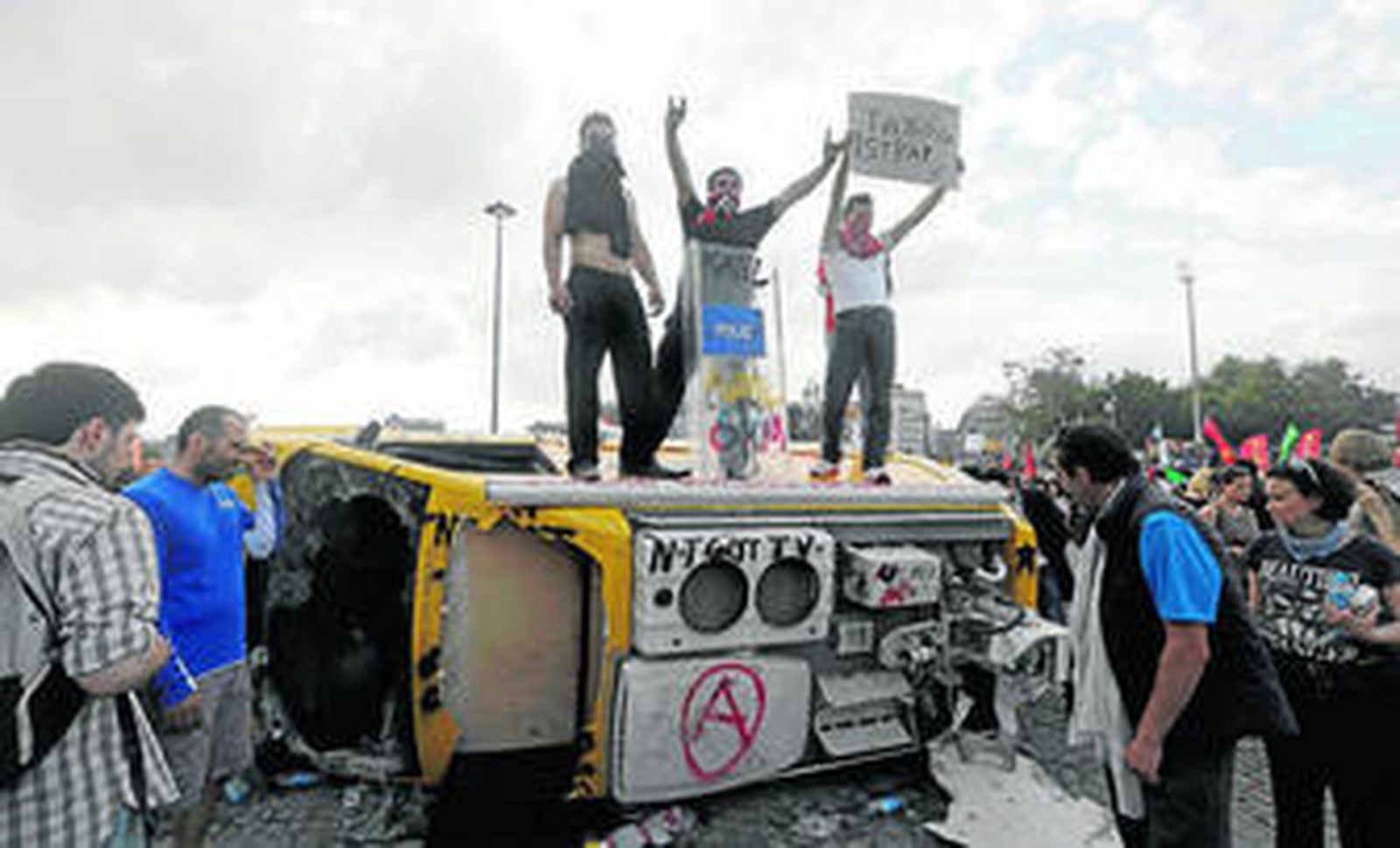 Un grupo de manifestantes subidos a una furgoneta de la televisión turca en Estambul con pancartas en contra de Erdogan.
