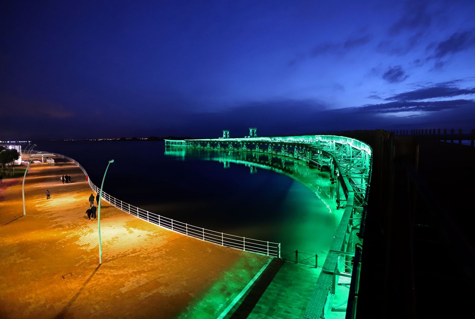 El muelle de la Riotinto se ilumina de verde en el día mundial contra el cancer