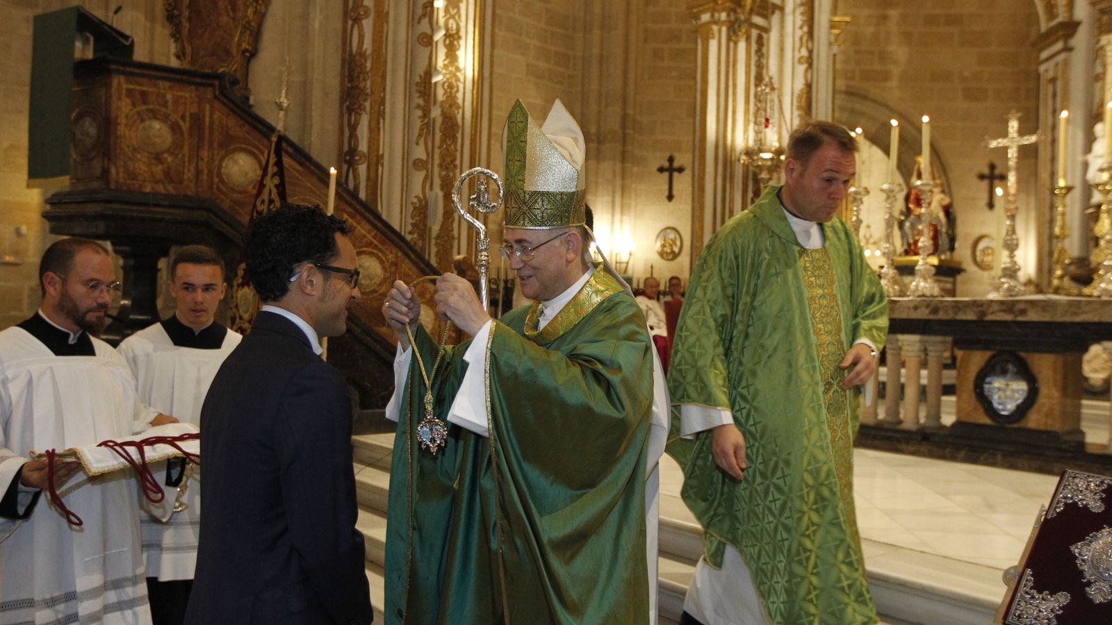 El obispo impone la medalla al nuevo presidente de la Agrupación.