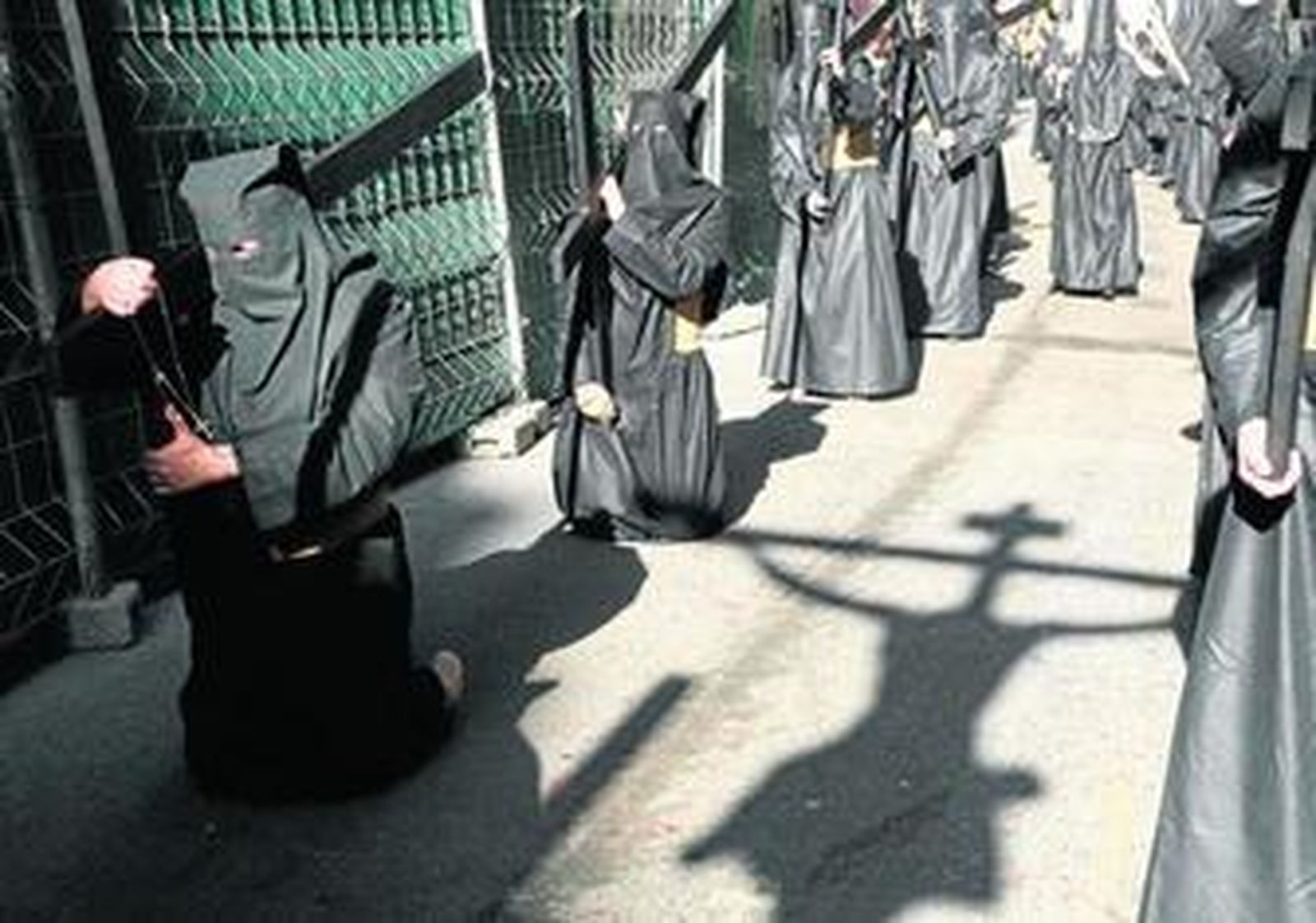 Penitentes de Dolores de San Juan tras el Crucificado, el Viernes Santo, tras la salida de la procesión.