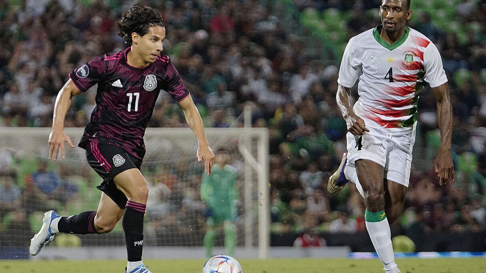 Diego Lainez conduce la pelota ante Malone.