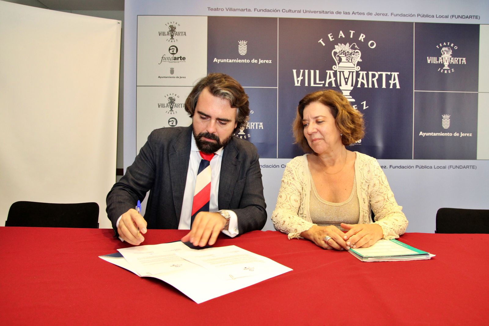 Eduardo Bárcena e Isamay Benavente, firmando el acuerdo.