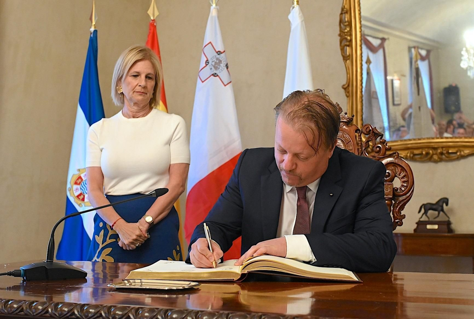 El alcalde de Victoria, Brian Azzopardi, firmando en el Libro de Honor de la Ciudad.