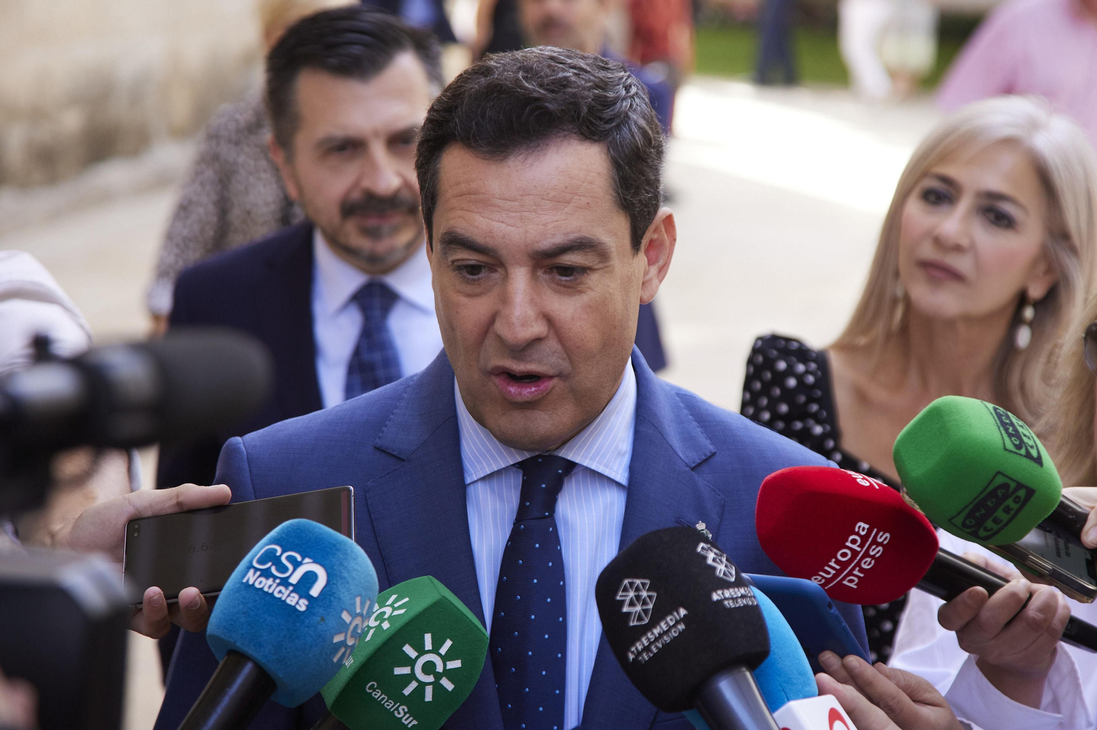 Juanma Moreno atiende a la prensa en el exterior del Parlamento andaluz.