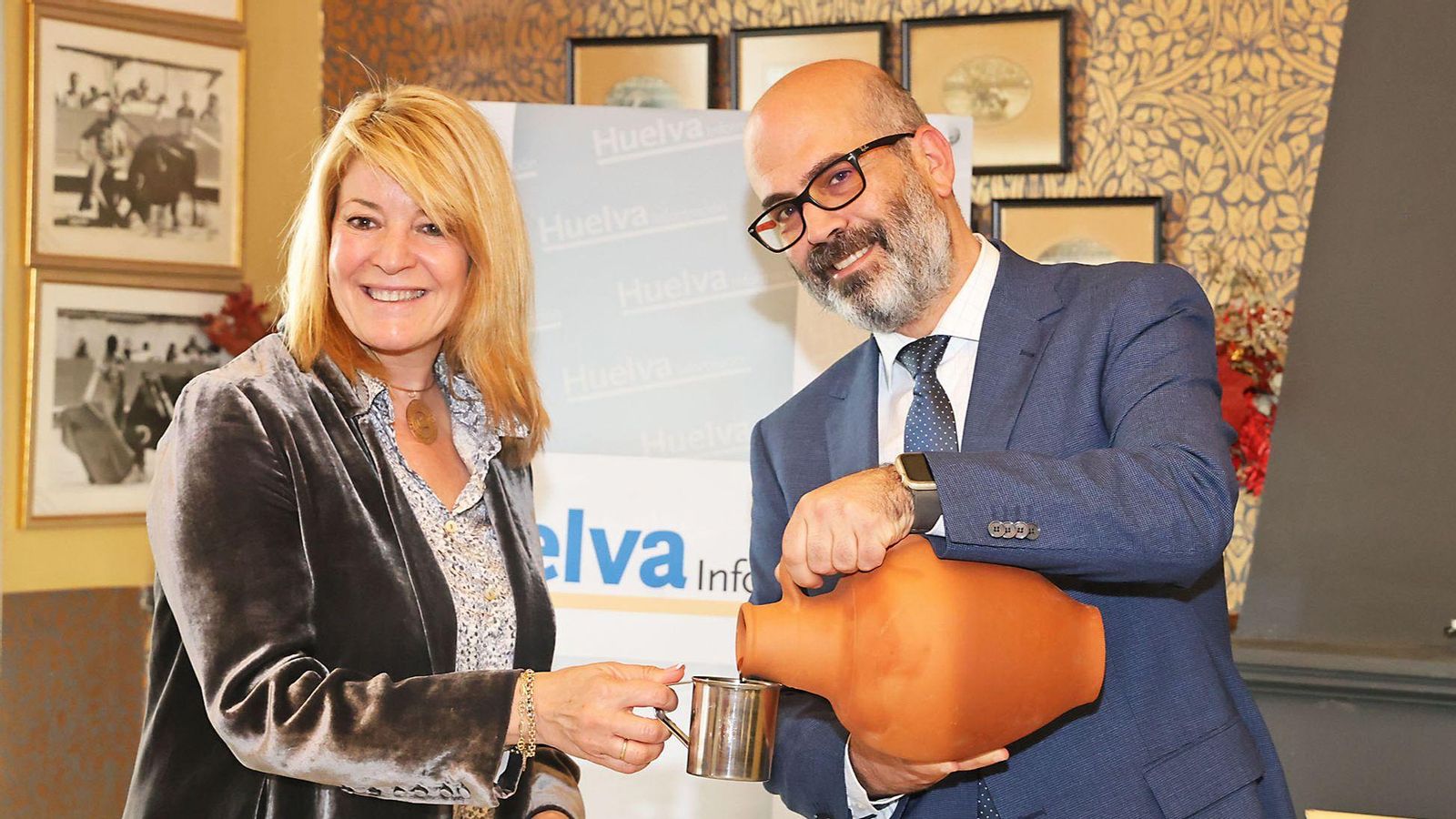 Javier Ronchel, director de Huelva Información, cumple con la tradición de la tertulia y sirve agua del botijo a Pilar Miranda