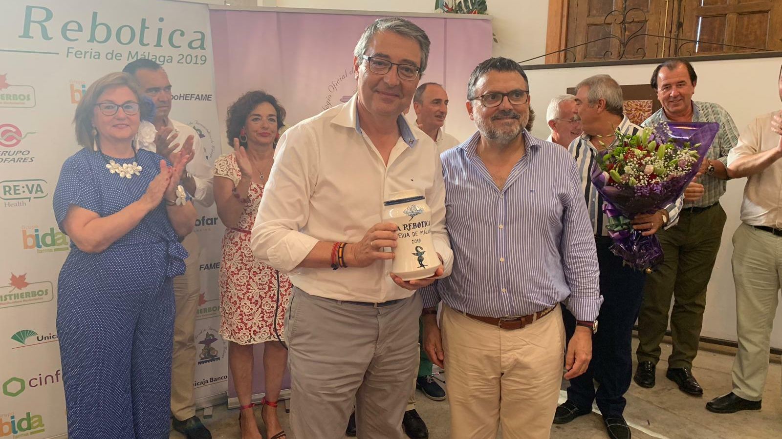 Salado recibe el galardón 'H de Oro' de manos del presidente del Colegio de Farmacéuticos de Málaga.