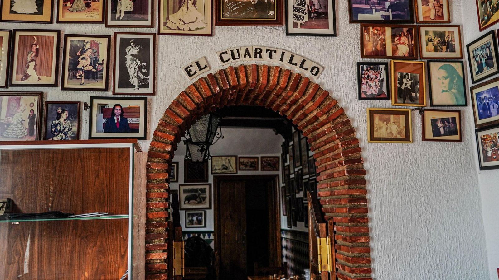 Otra de las zonas, con inmumerables imágenes de artistas del flamenco sobre sus parece y la puerta de acceso al cuartillo