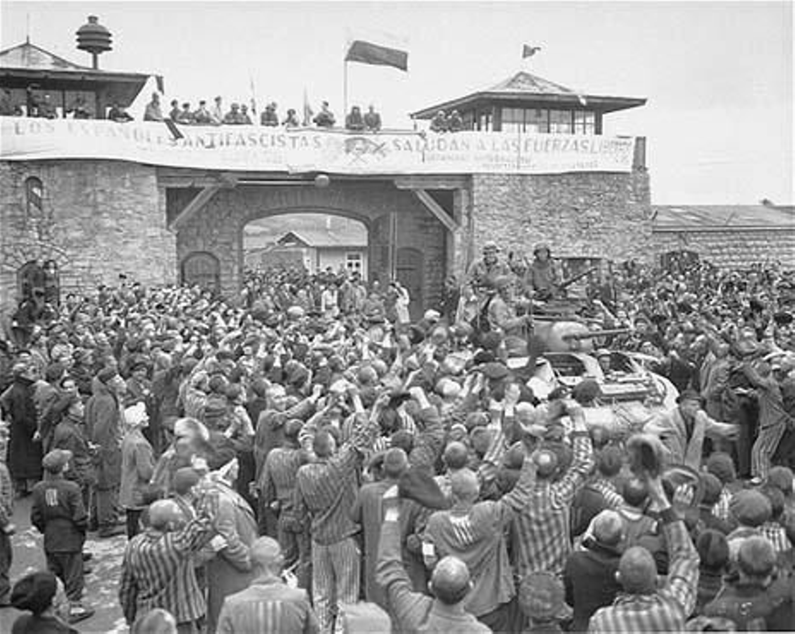 Supervivientes de Mauthausen aclaman a los soldados estadounidenses que los han liberado. La pancarta en español les da la bienvenida.