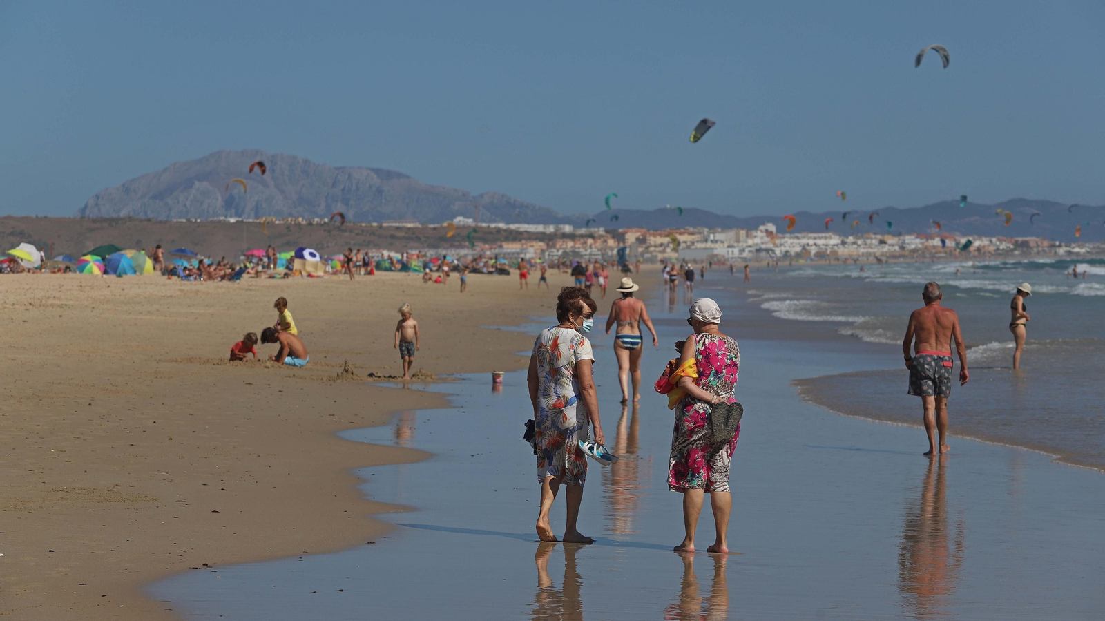 Dos mujeres pasean por la orilla de la playa de Bolonia, el pasado domingo.