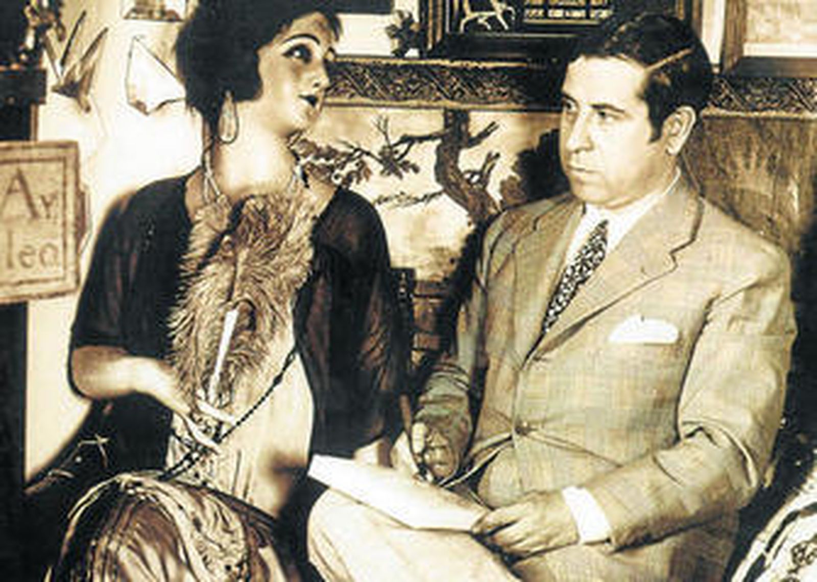 Ramón Gómez de la Serna, sentado junto a una muñeca de cera a tamaño real.