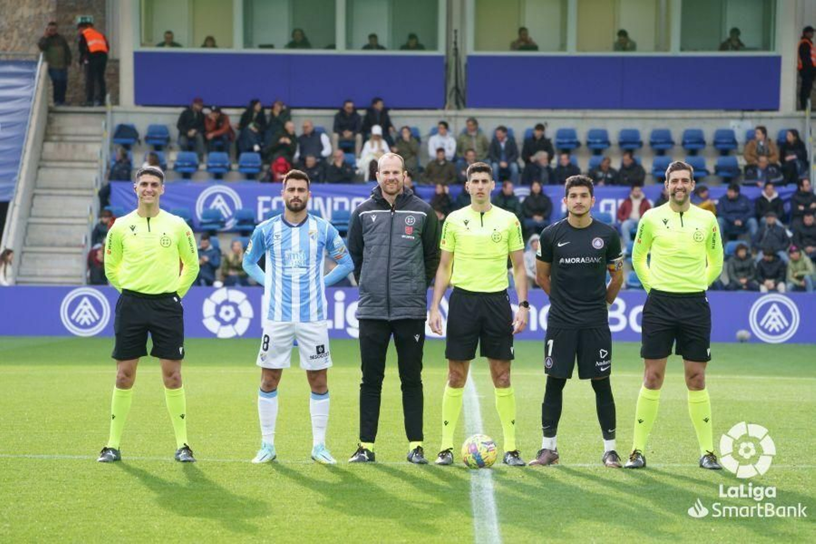 Luis Muñoz posando con el trio arbitral y el capitán rival.