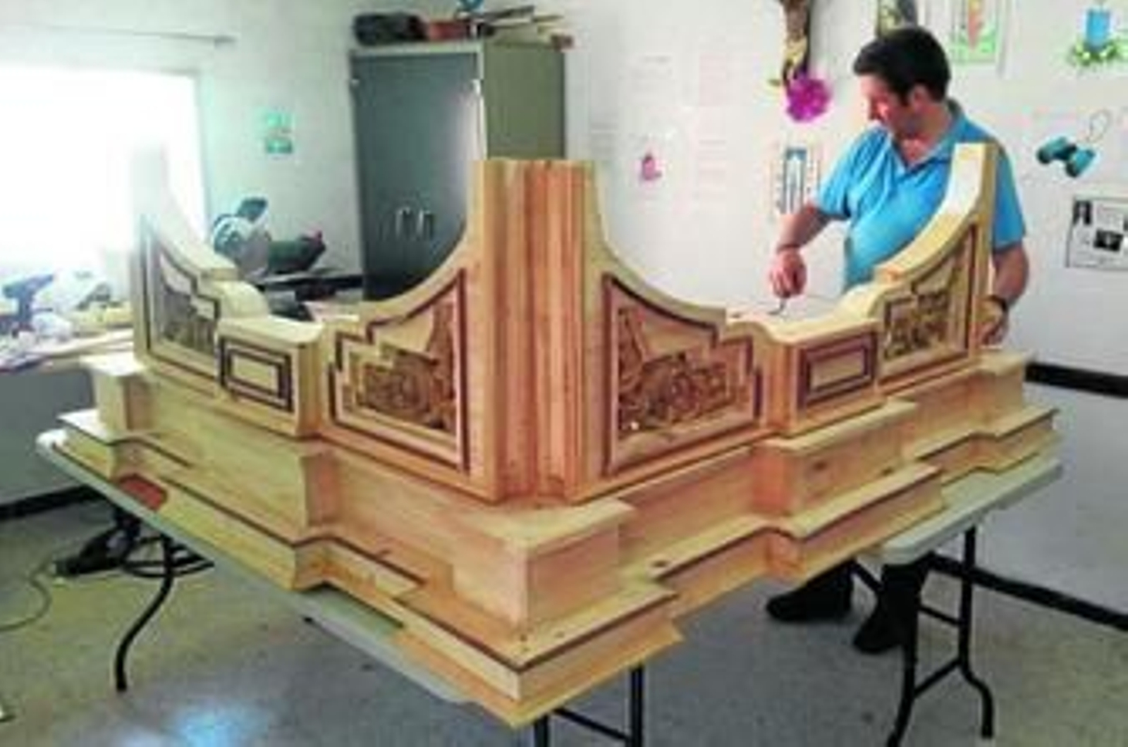 Luis Benítez, trabajando en el templete (boca abajo) que está haciendo para la Virgen de las Lágrimas.