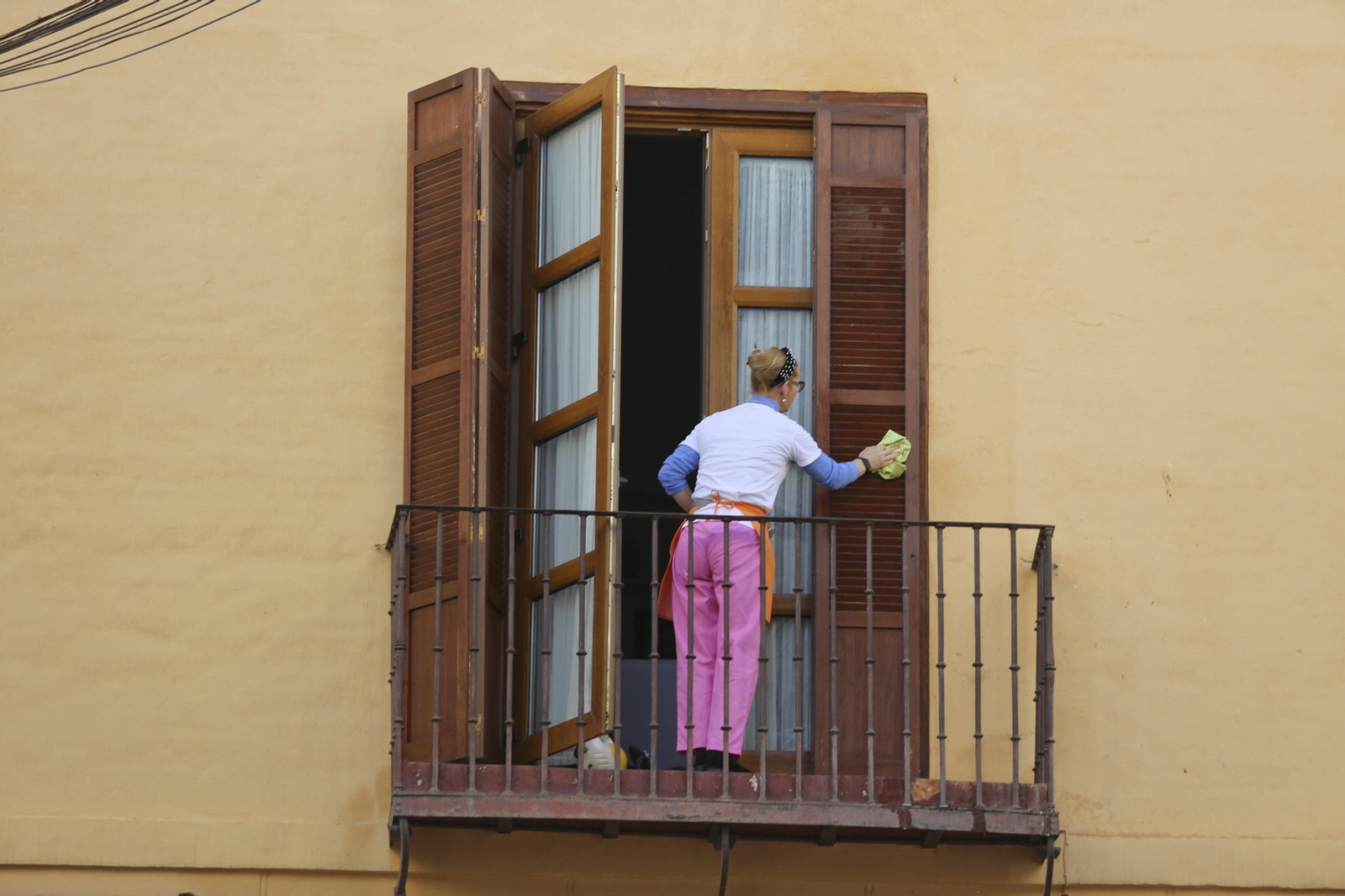 Una mujer limpia una ventana.