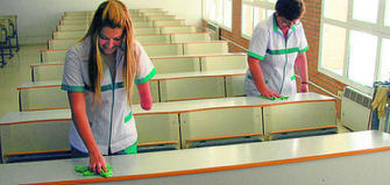 Dos trabajadoras se encargan de la limpieza de una de las aulas de la Universidad de Almería en un claro ejemplo de que la discapacidad no debe tener barreras.