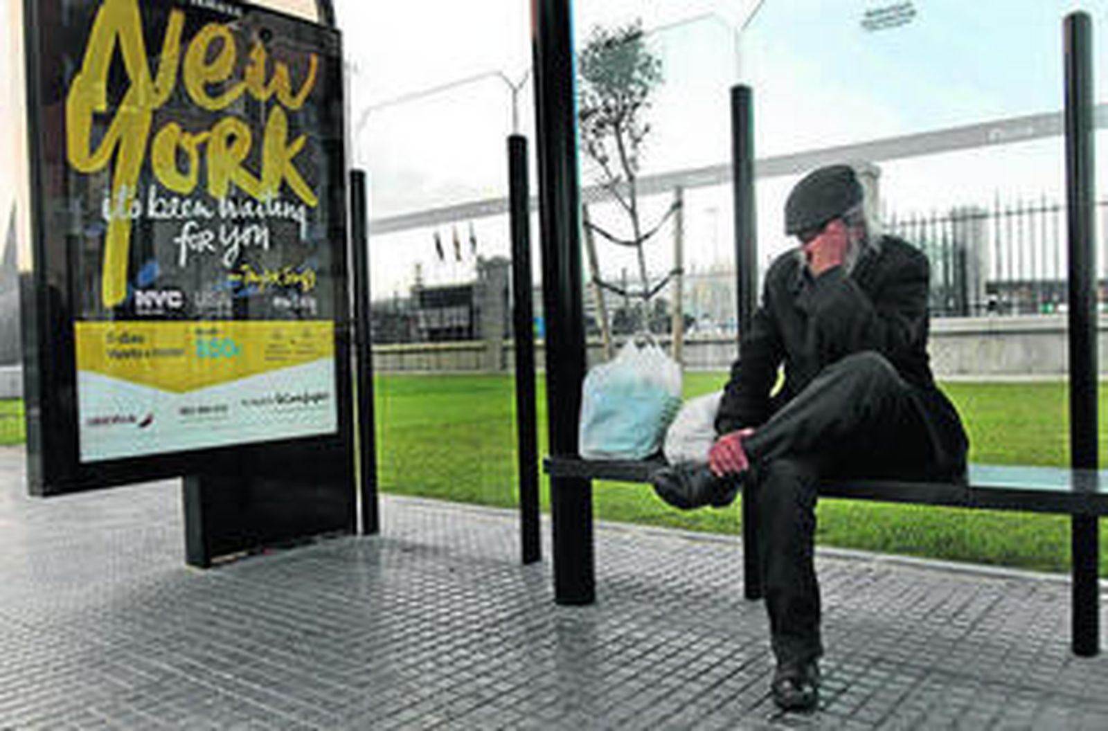 Un hombre sin techo en la marquesina de la parada del autobús junto a la Casa del Mar.