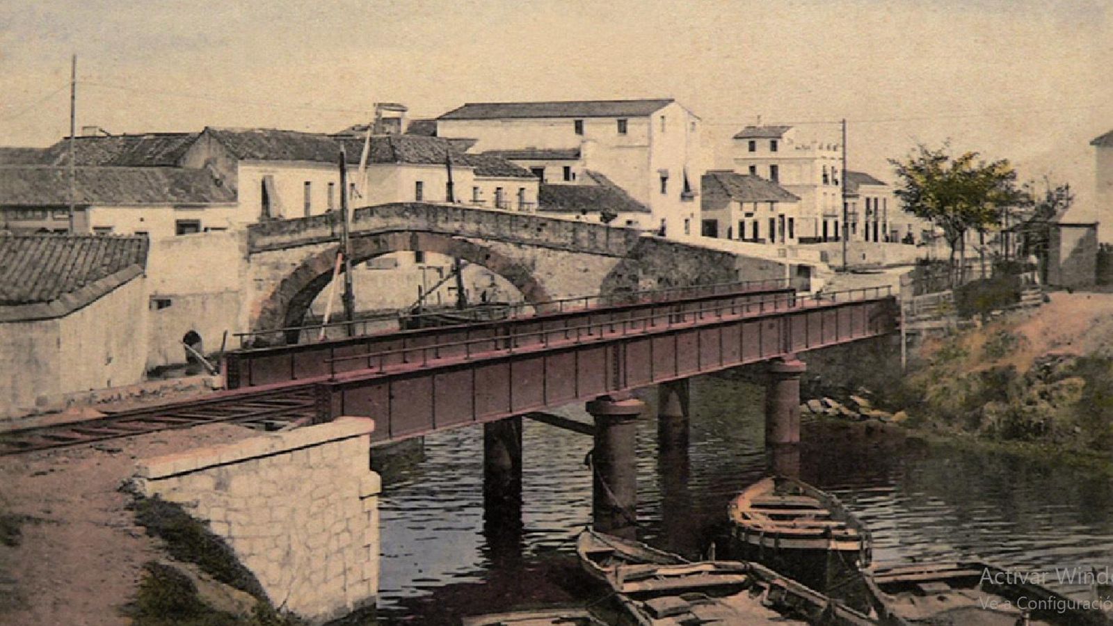 Postal coloreada, comercializada en los primeros años del siglo XX (antes de 1905) en la que aparece, en primer término, el puente de hierro del ferrocarril y, detrás, el puente Viejo o del Cristo.