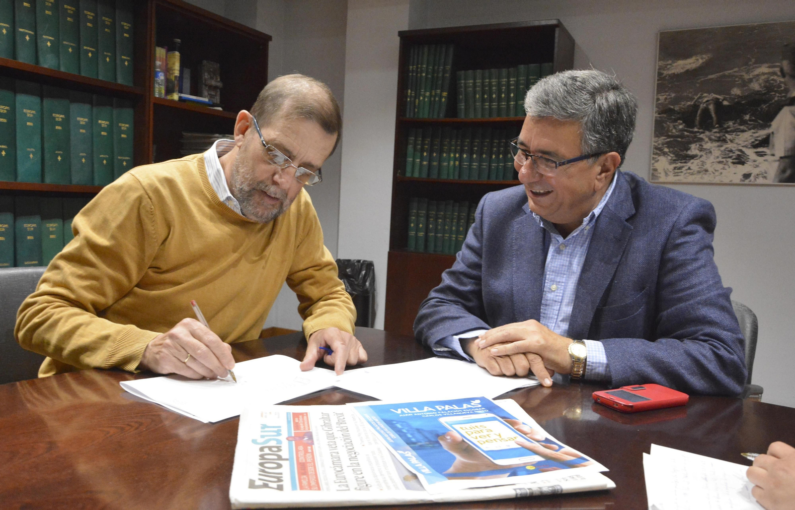 Carlos Villanueva, dibujando una viñeta en un folio ante la mirada de Juan Antonio Palacios, en la redacción de 'Europa Sur'.