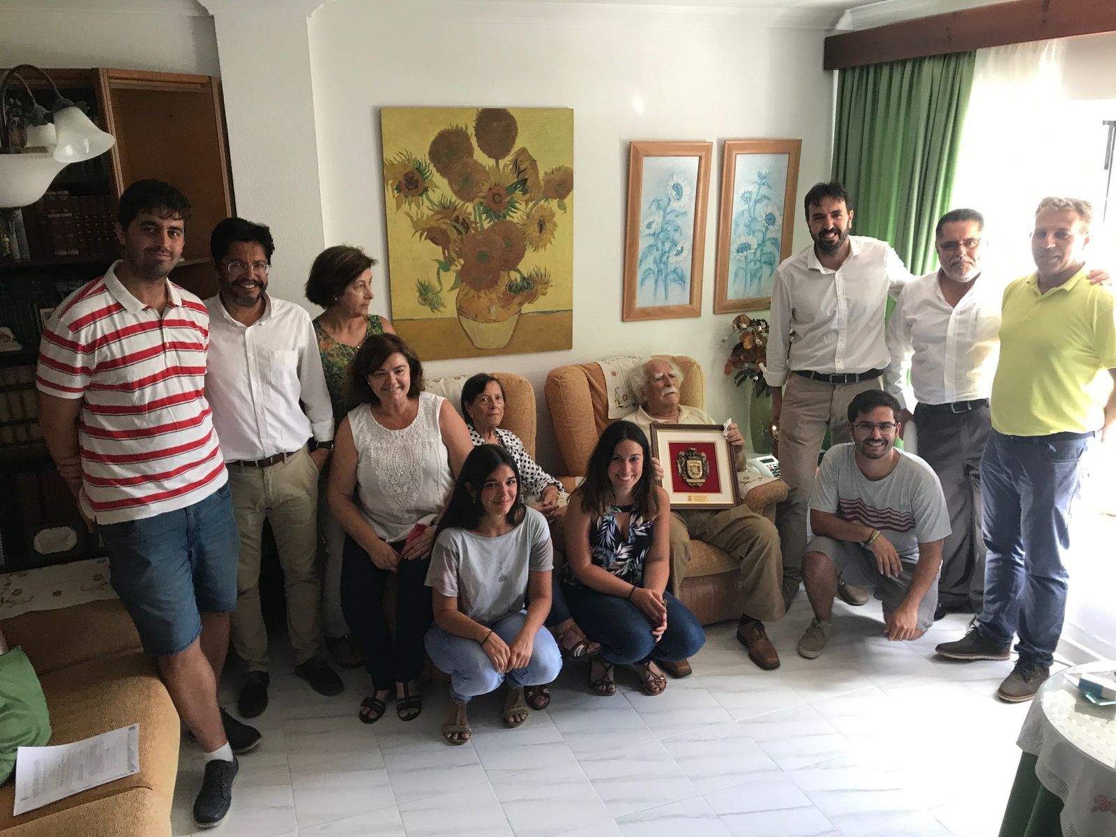 Carlos Romero, con el título, rodeado de su familia en su casa hace un mes.