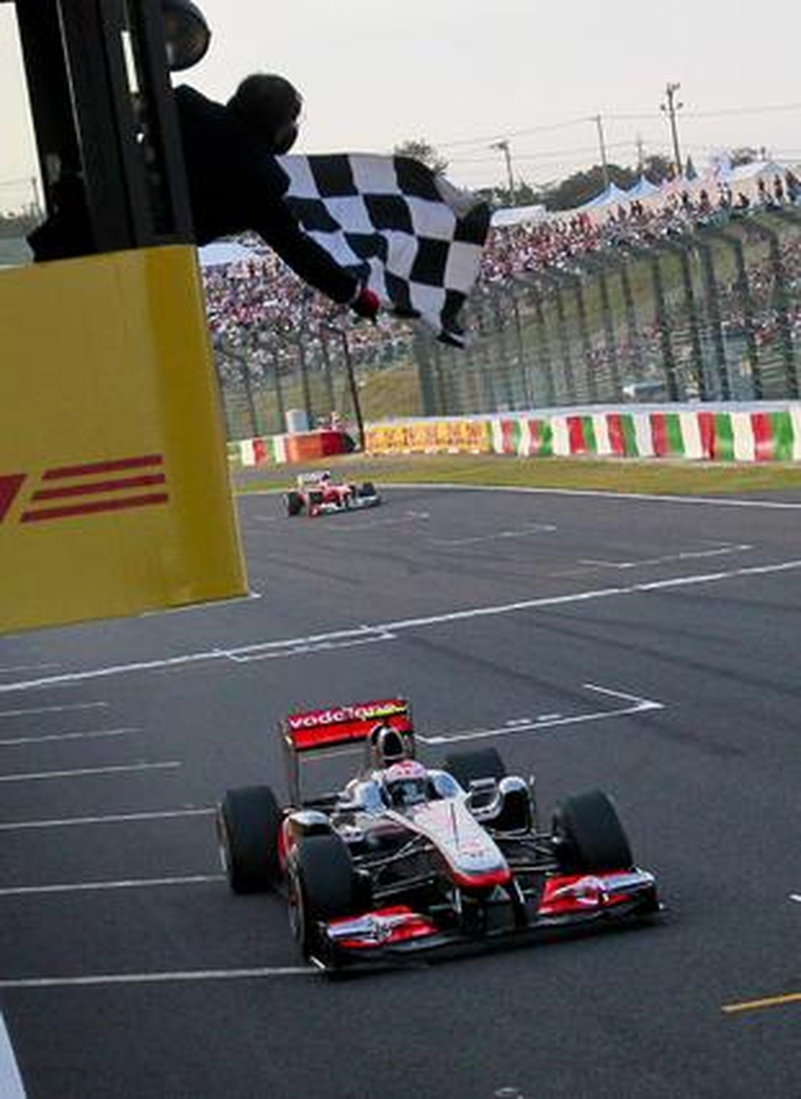 Button pasa por debajo de la bandera de cuadros seguido de Alonso. / EFE