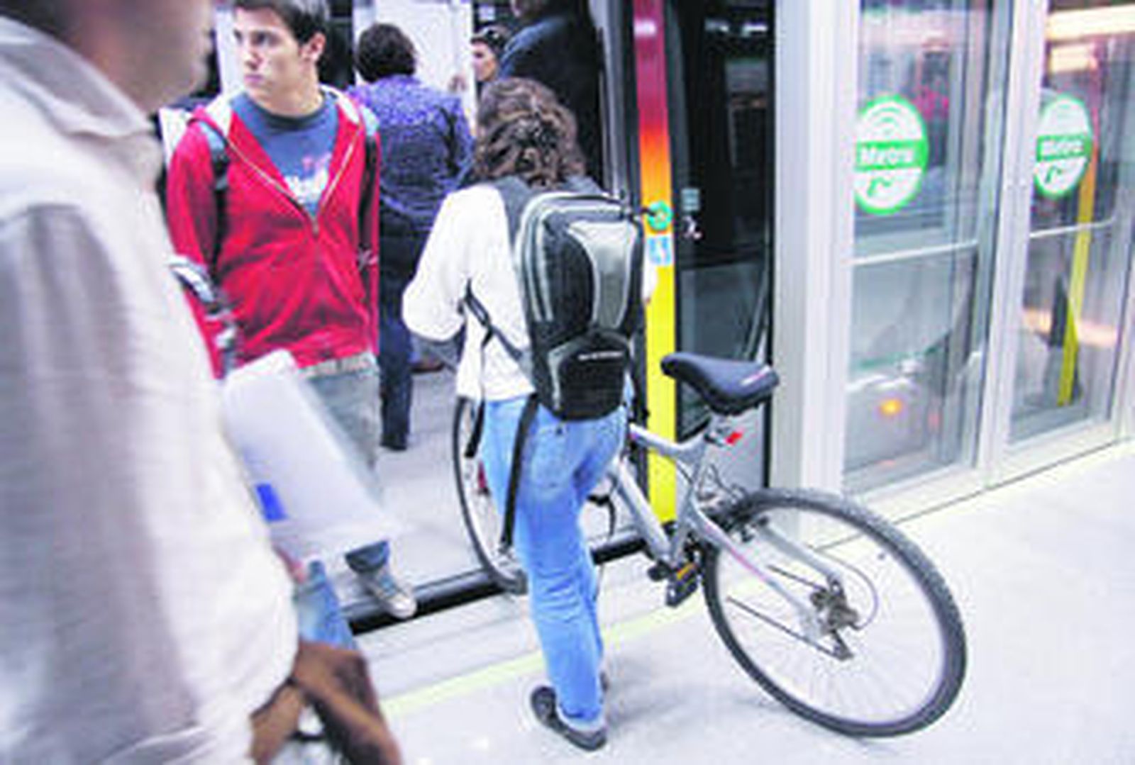 Una mujer introduce una bicicleta en un vagón del Metro de Sevilla.