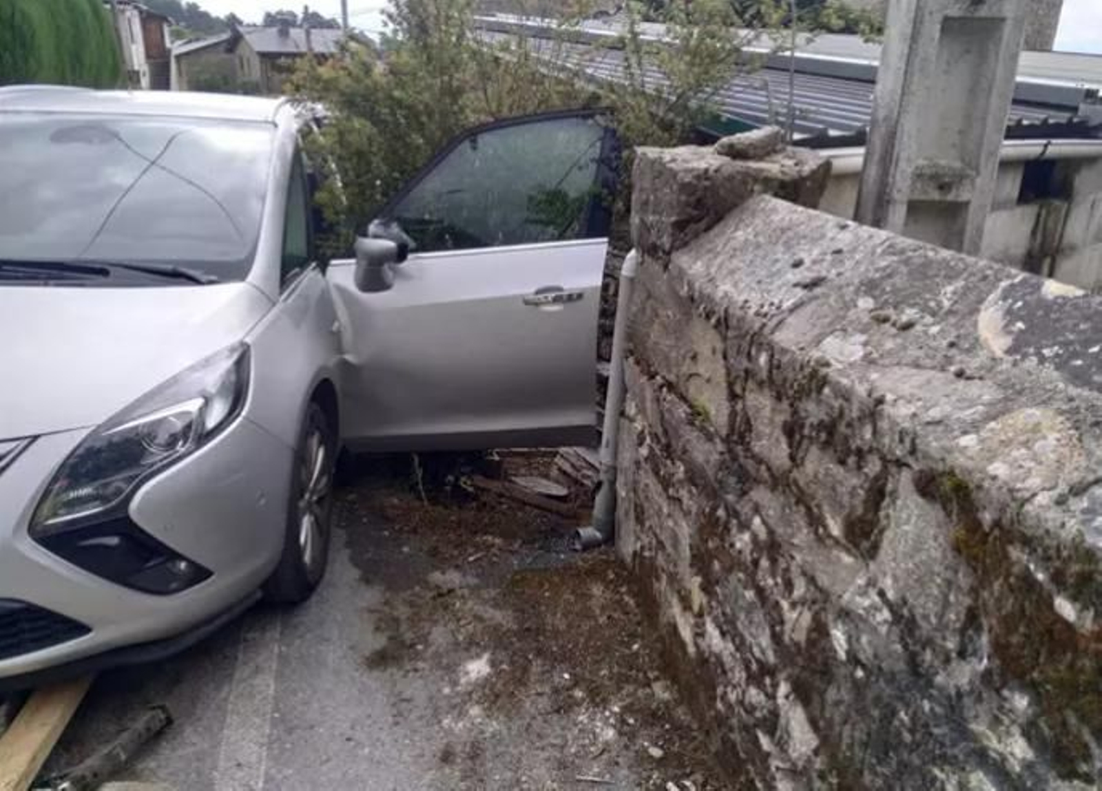 El vehículo de la víctima, tras descender varios metros y colisionar contra un muro de piedra El vehículo de la víctima, tras descender varios metros y colisionar contra un muro de piedra