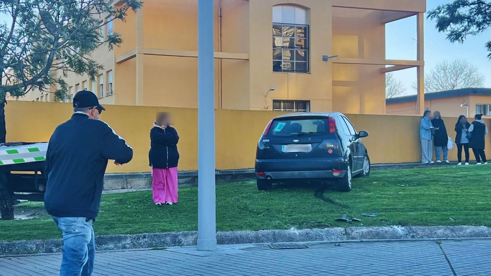 La conductora perdió el control del vehículo al tomar la rotonda, se subió a la acera, atravesó una acequia y terminó su recorrido sobre el césped que bordea el Colegio Mediterráneo.