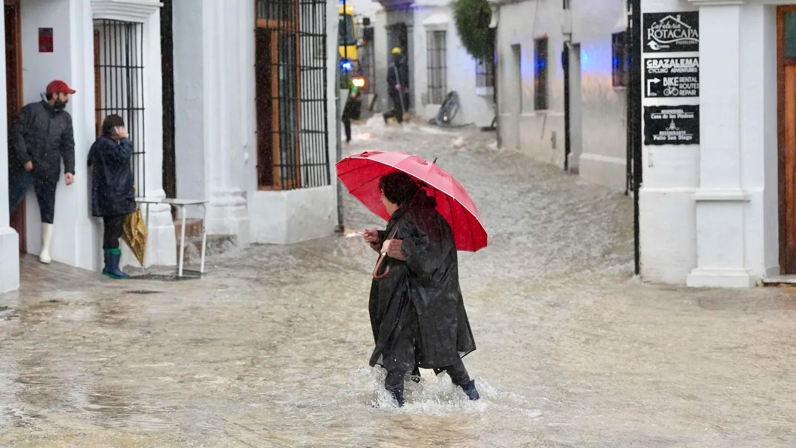 Vecinos de Grazalema en una calle inundada durante el temporal antes del desalojo.