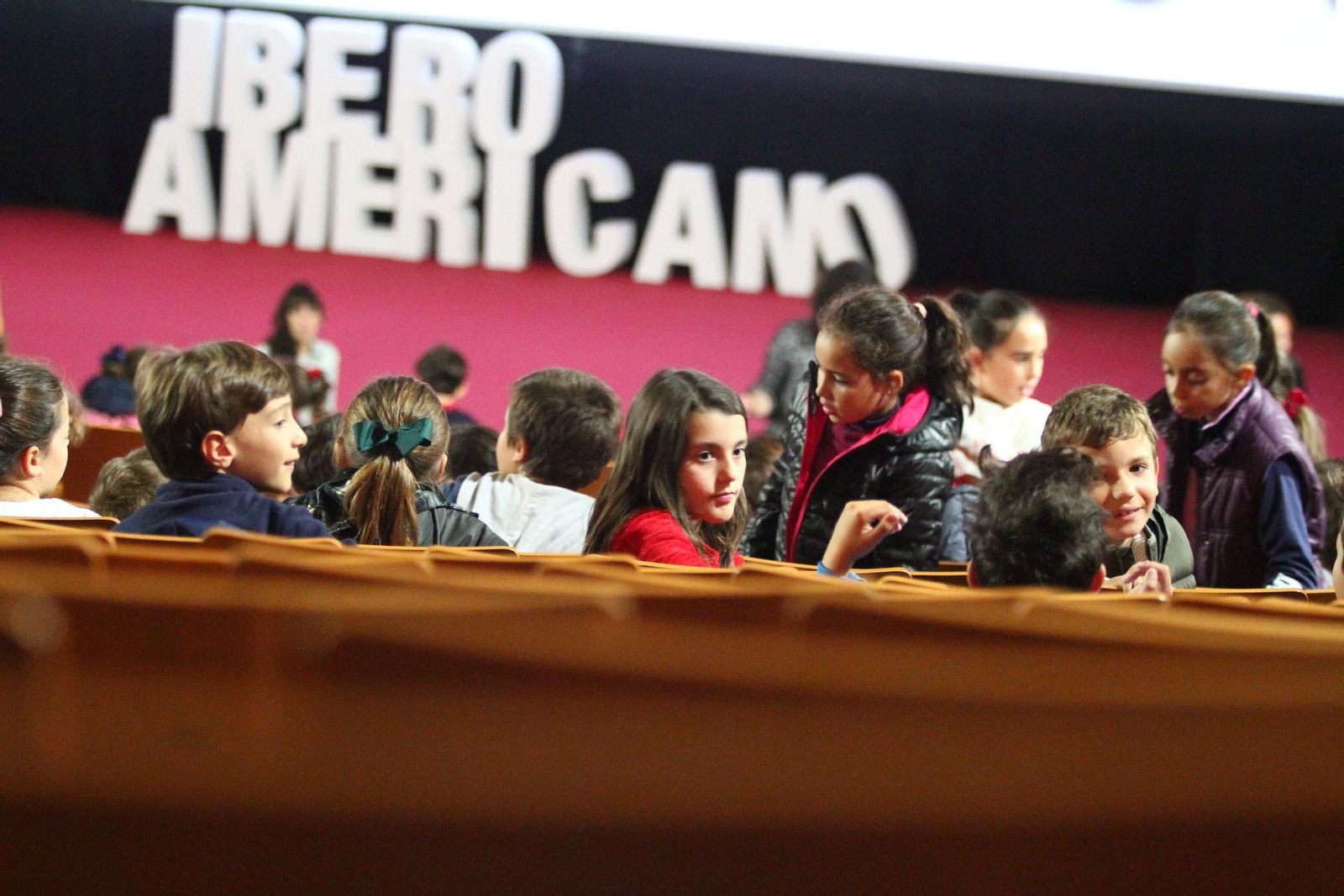 Varios escolares aguardan el comienzo de una sesión en el auditorio de la Casa Colón.
