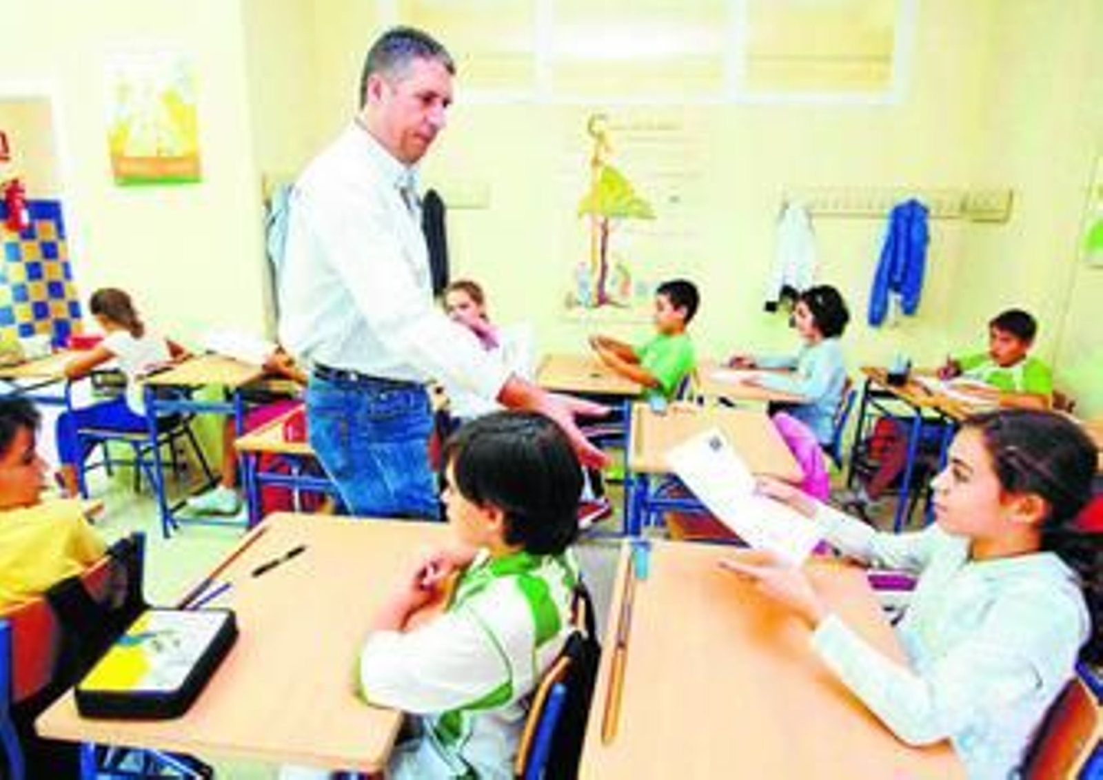 Un profesor reparte las pruebas de diagnóstico a una clase de Primaria.