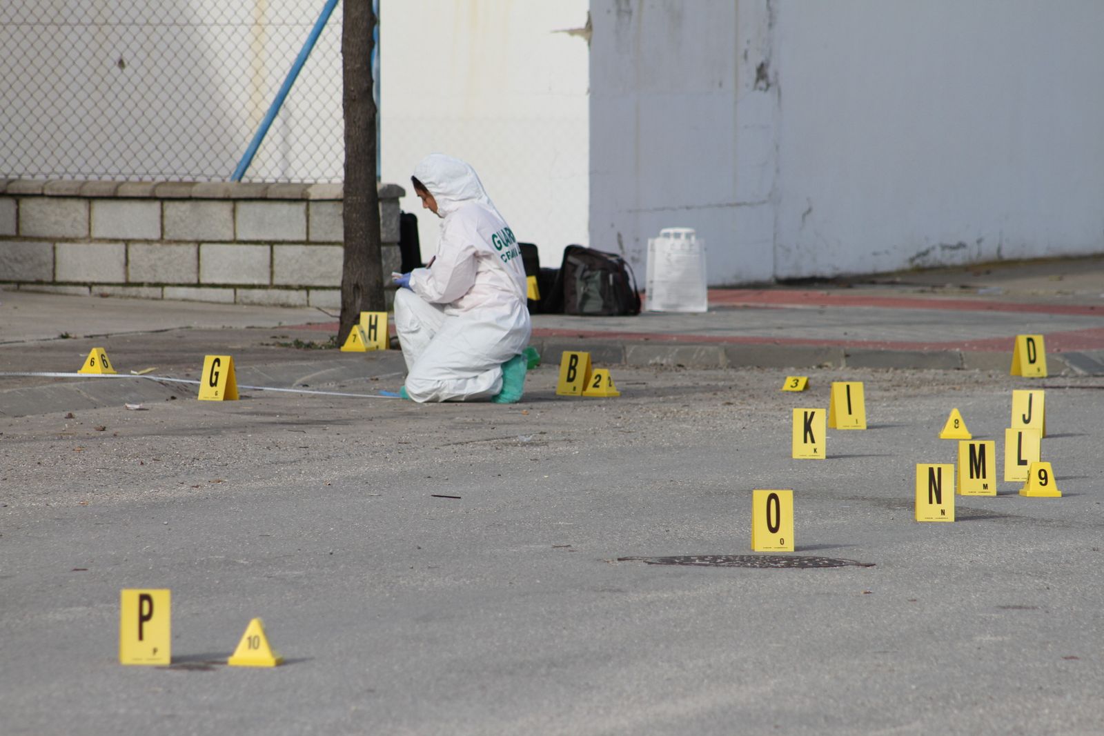 Una agente de Criminalística recoge muestras de sangre en la calle Italia de Medina.