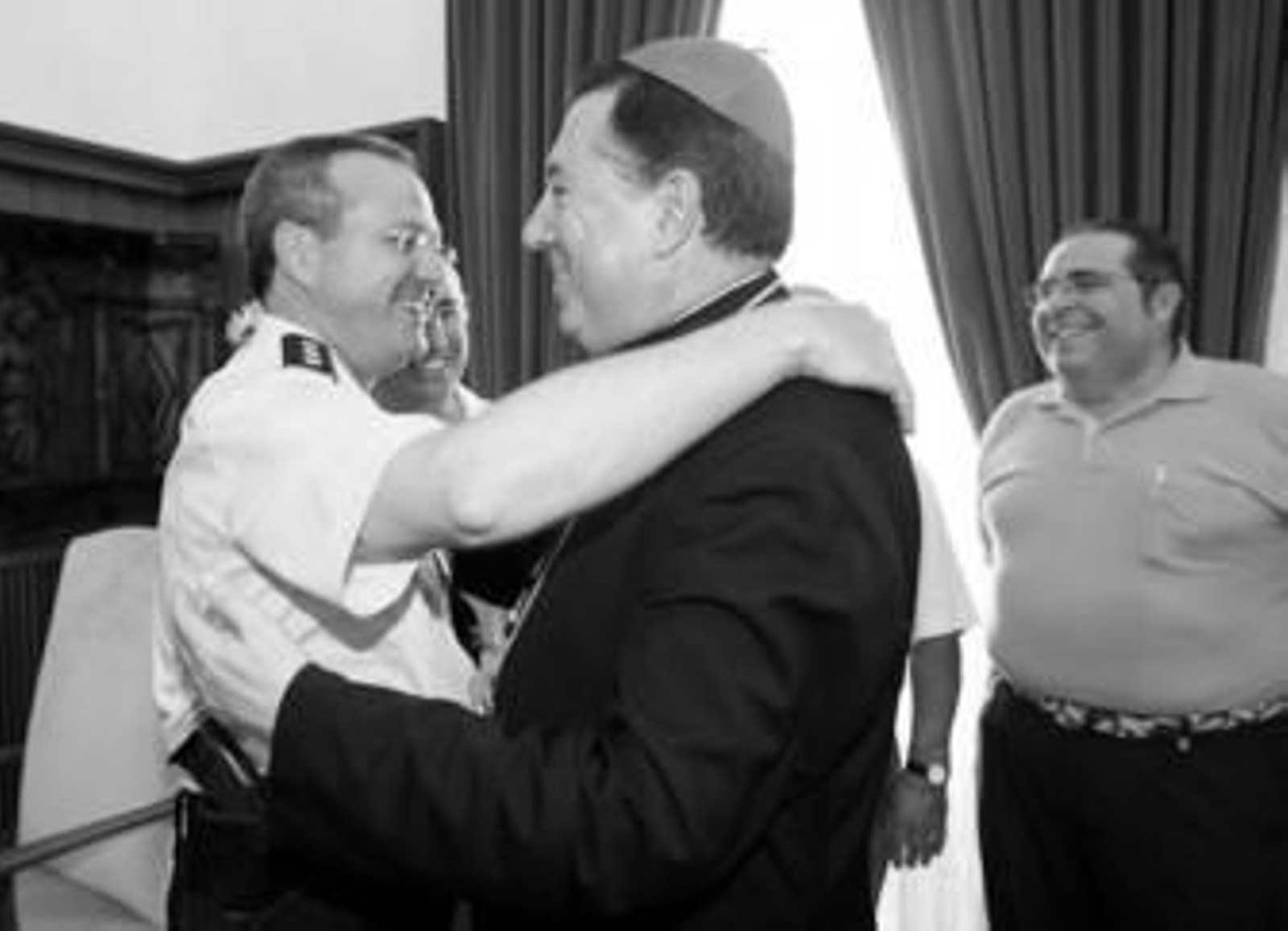 El obispo y flamante arzobispo castrense se funde en un abrazo con el comisario jefe del Cuerpo Nacional de Policía en Jerez, Andrés Garrido.