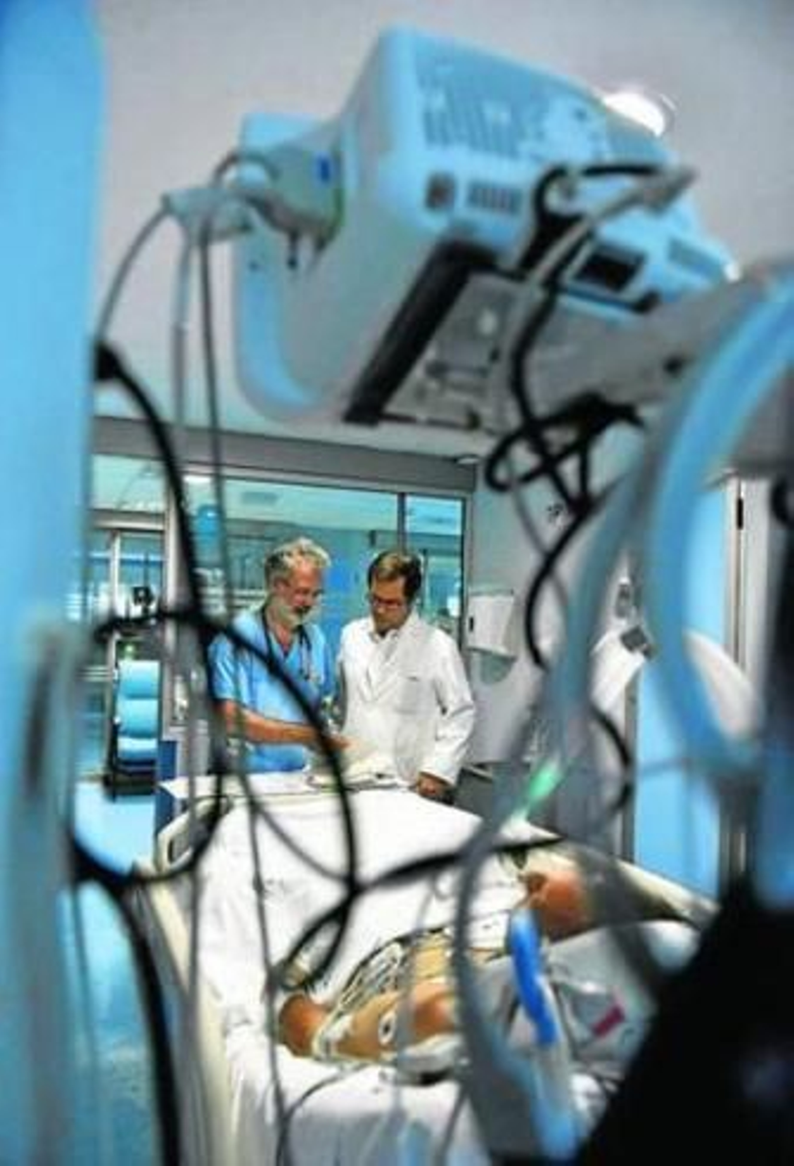 El doctor Rafael Hidalgo junto a otro especialista atiende a un paciente.