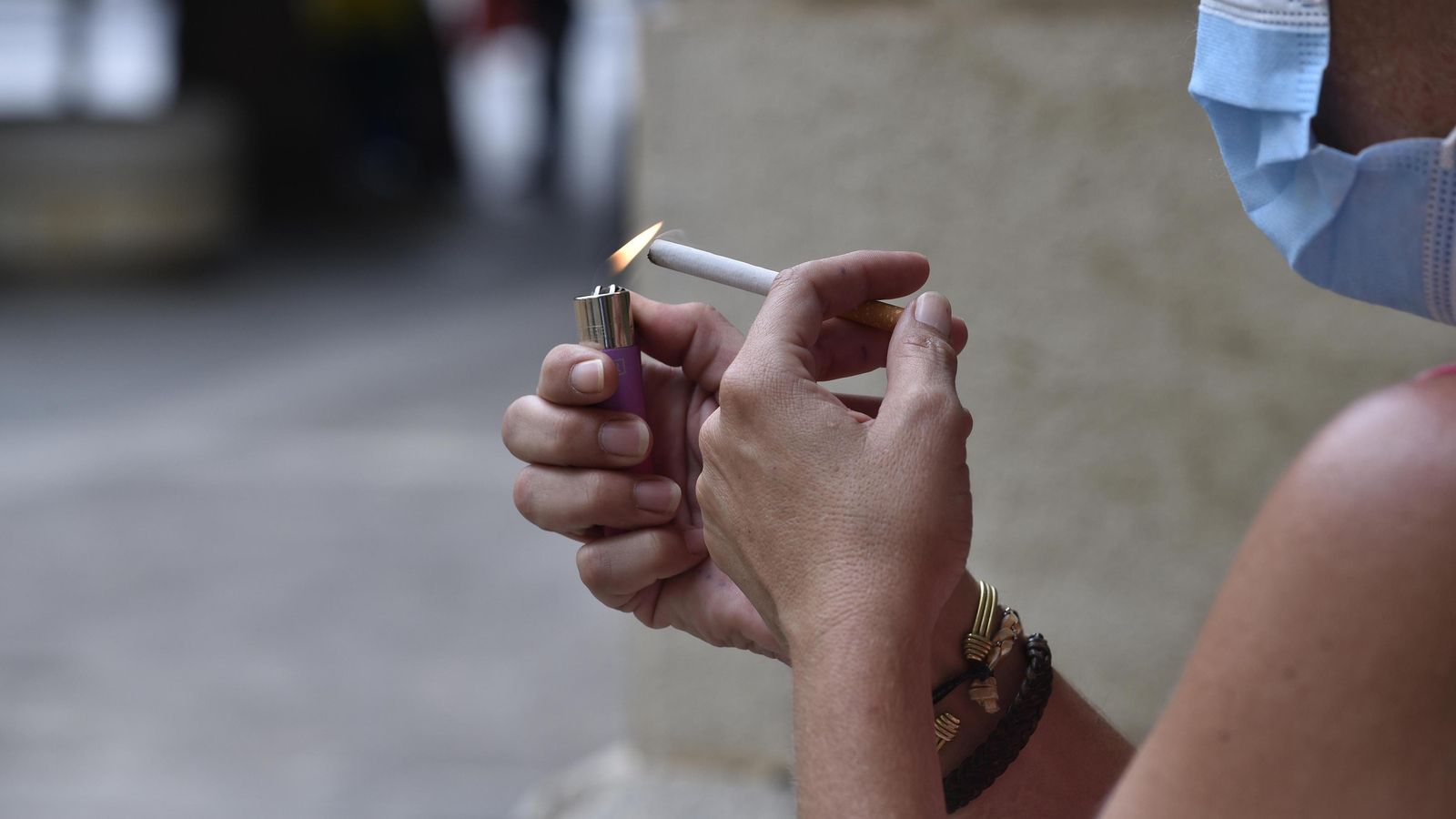 Una mujer se enciende un cigarrillo.