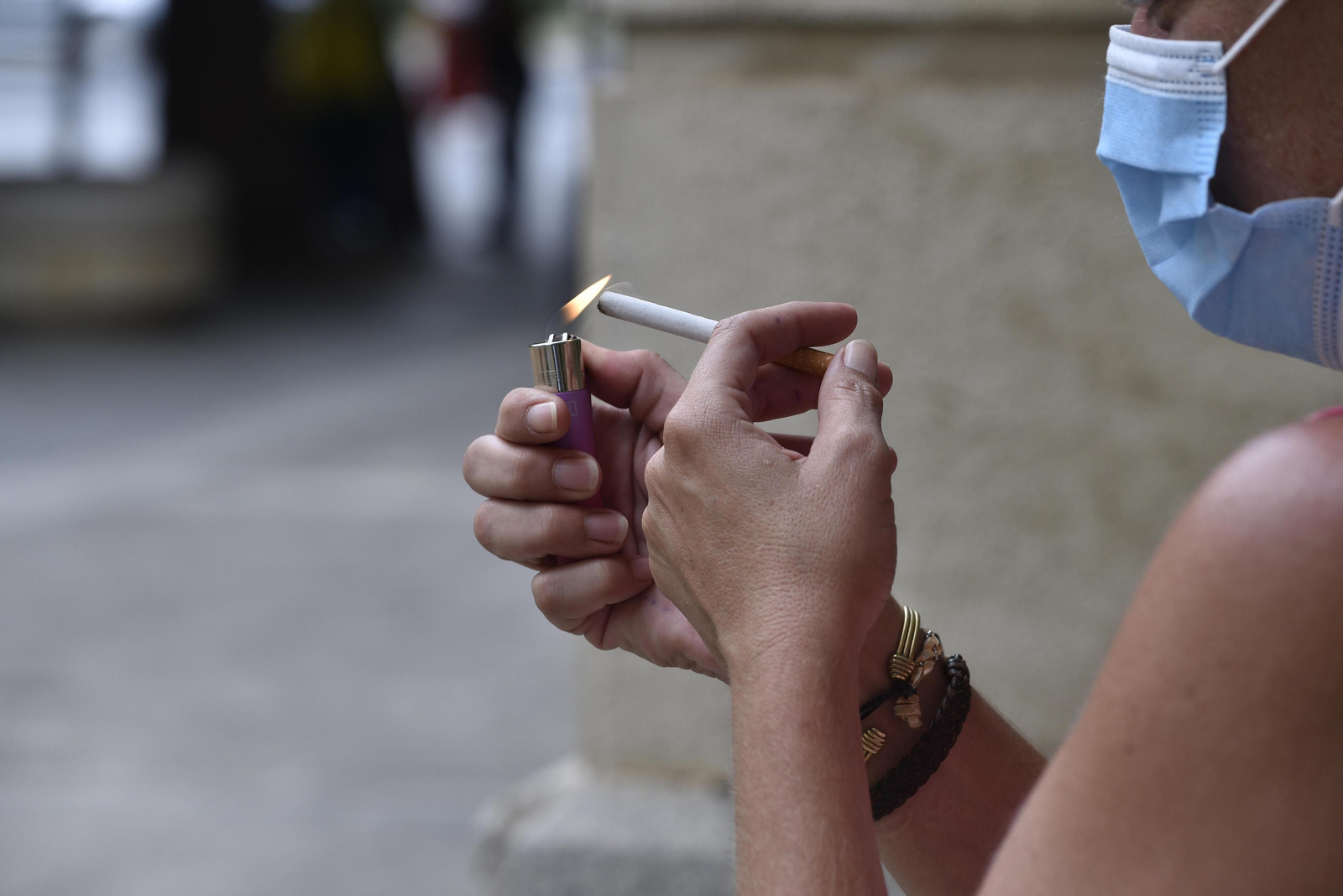 Una mujer se enciende un cigarrillo.