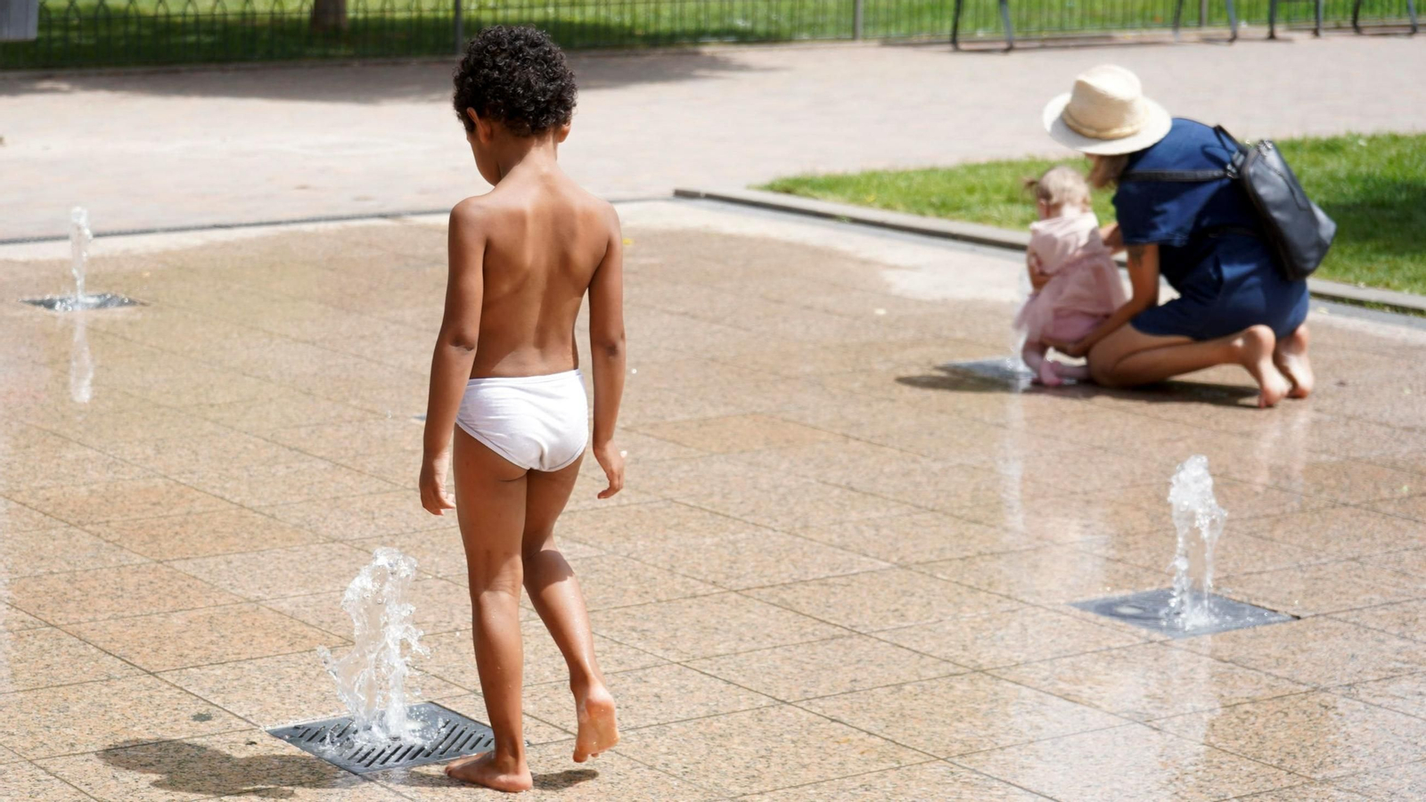 Niños acuden al agua de unas fuentes para refrescarse en Granada Niños acuden al agua de unas fuentes para refrescarse en Granada