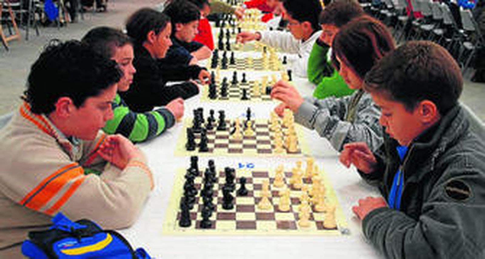 Los niños, concentrados ante el tablero de 64 casillas.