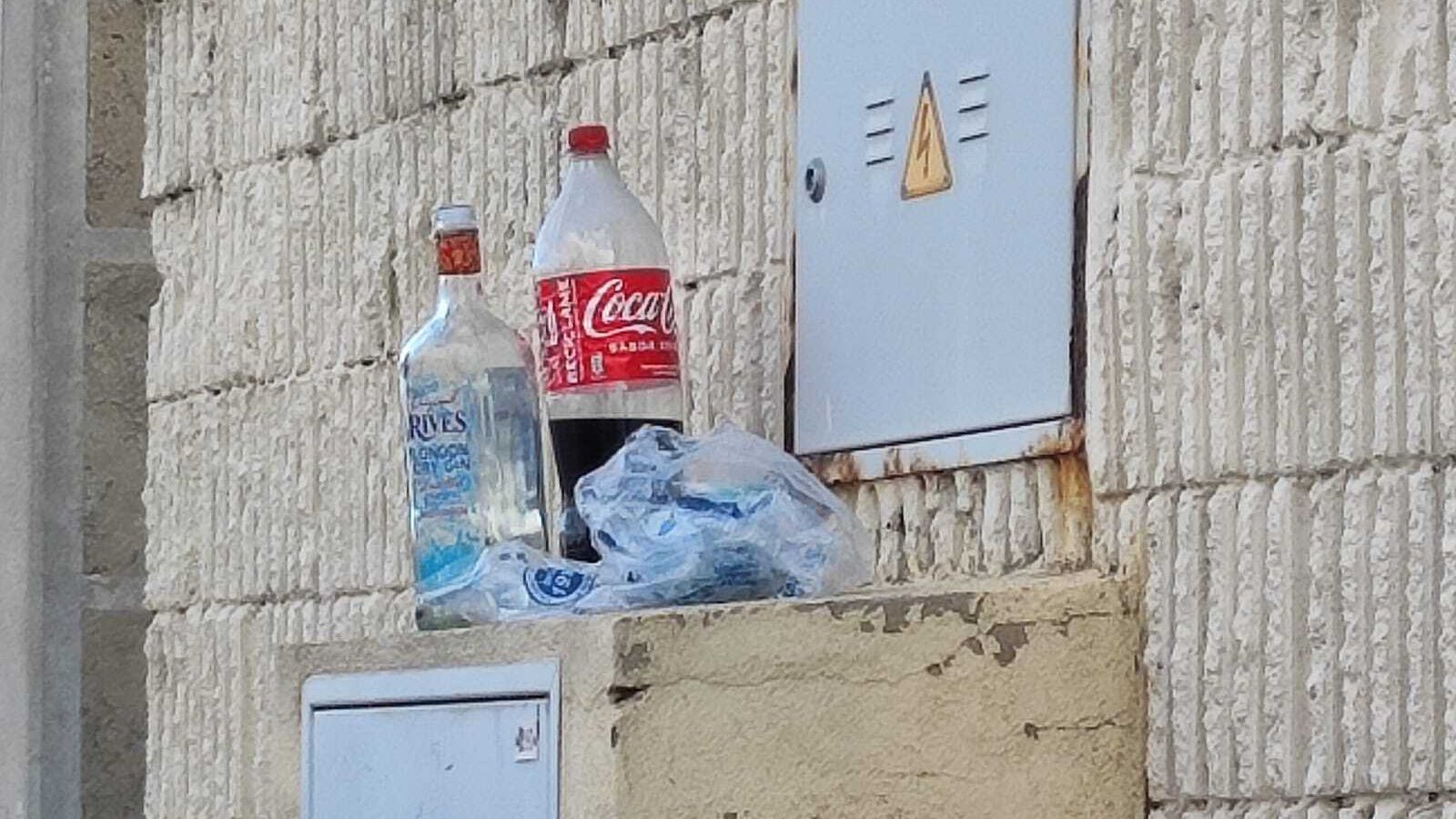 Botellas sobre una caja eléctrica en una calle del polígono de Fadricas.
