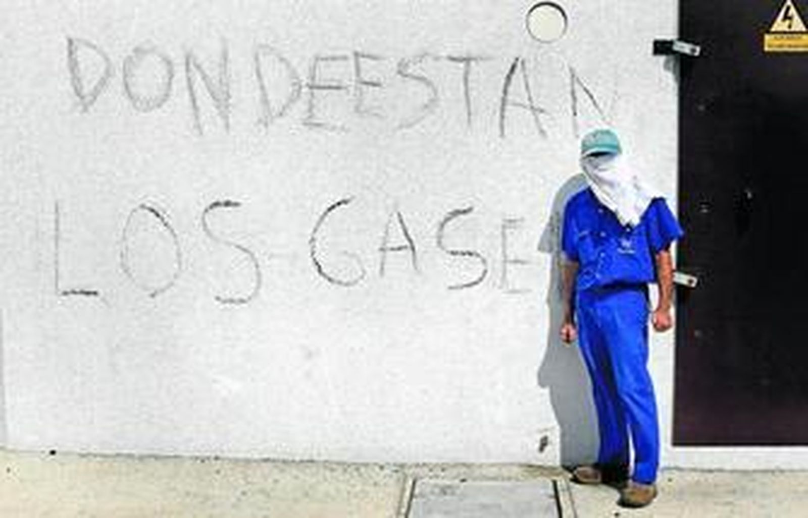 Un operario del astillero puertorrealeño, ante una pintada junto a la fábrica reclamando los gaseros.