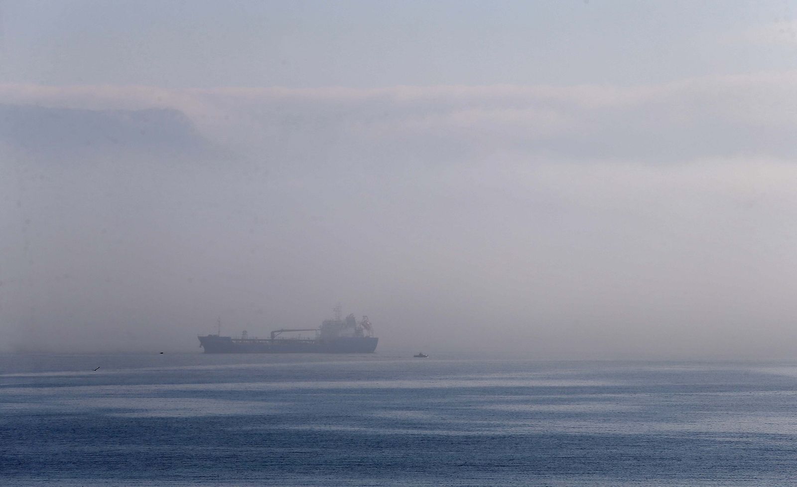 Un buque navega entre la bruma en el Estrecho, este martes.
