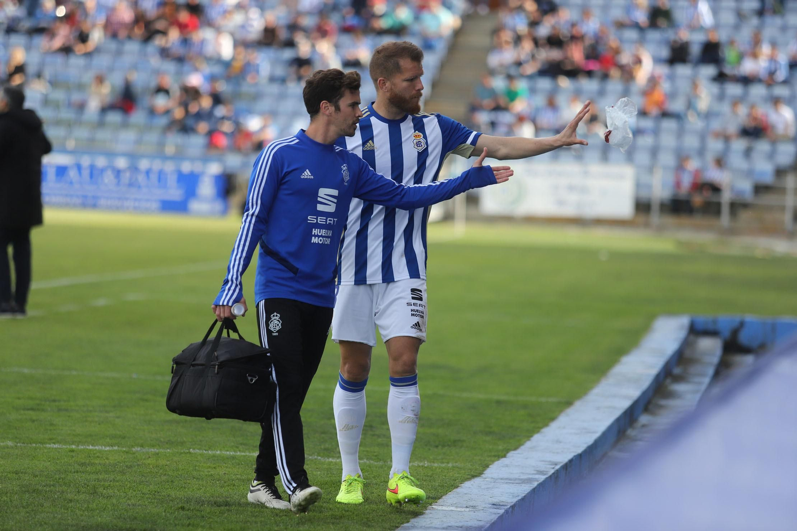 Morcillo, acompañado de un integrante de los servicios médicos del Decano, lanza una bolsa de hielo tras ser atendido.