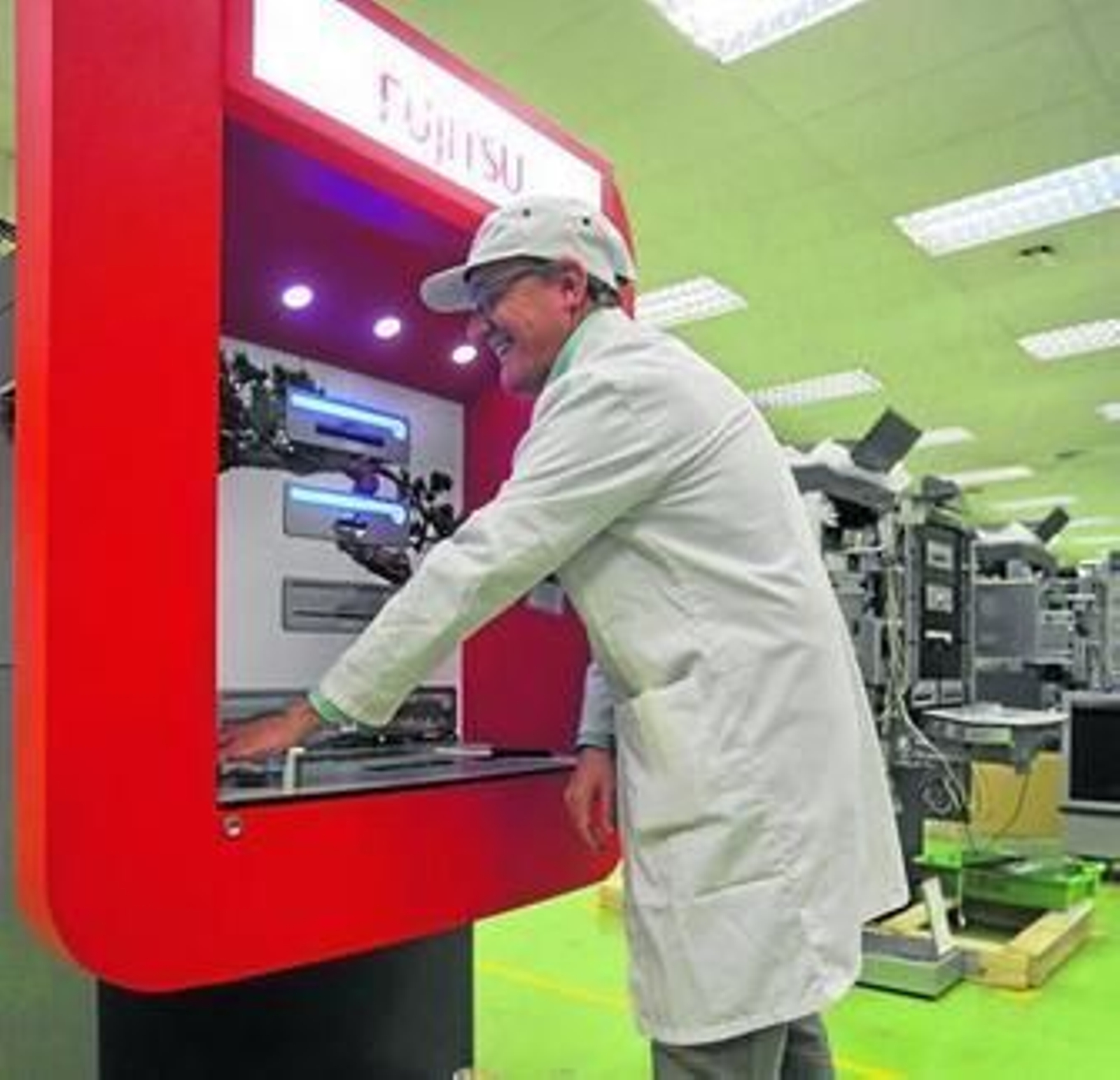 Un operario prueba uno de los cajeros desarrollados por Fujitsu que lee el mapa de venas de las manos.