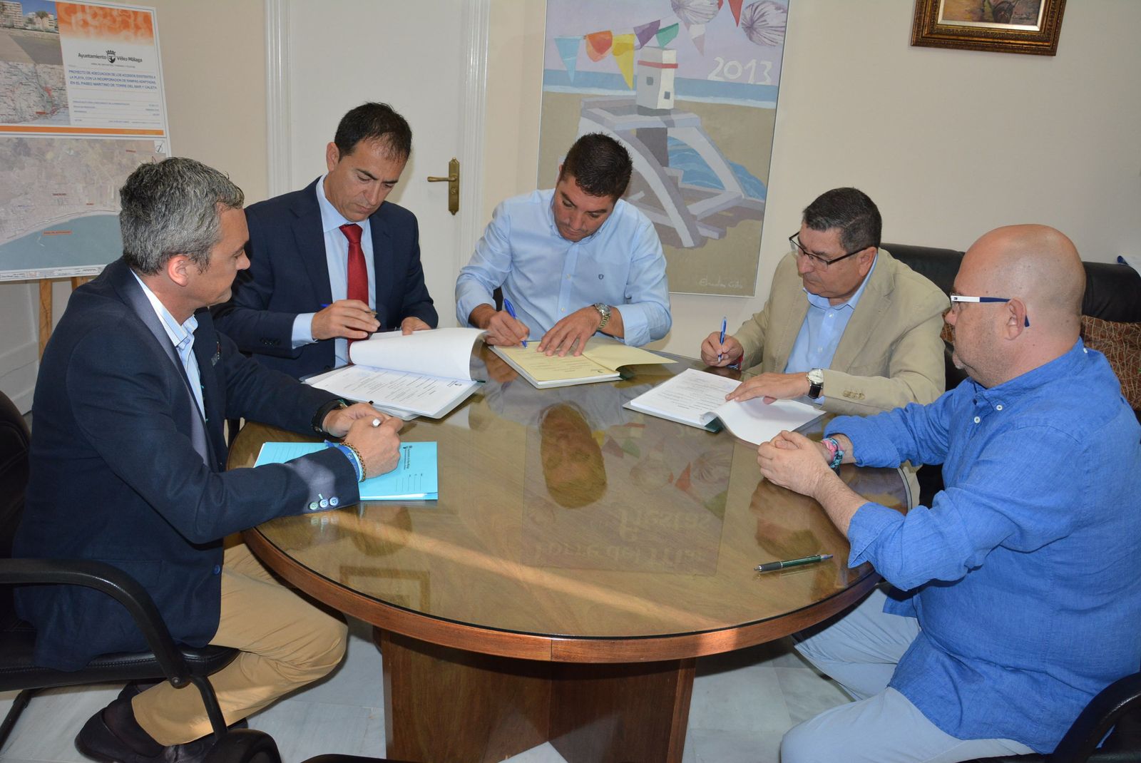 El alcalde firma el contrato con los responsables de la empresa adjudicataria.