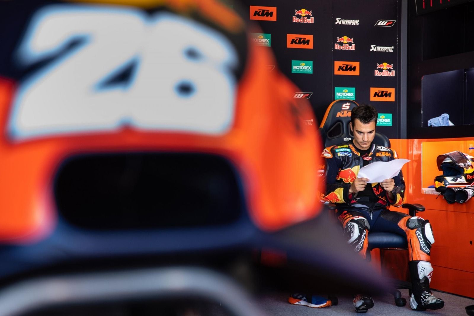 Dani Pedrosa repasa unos papeles en el box de KTM.